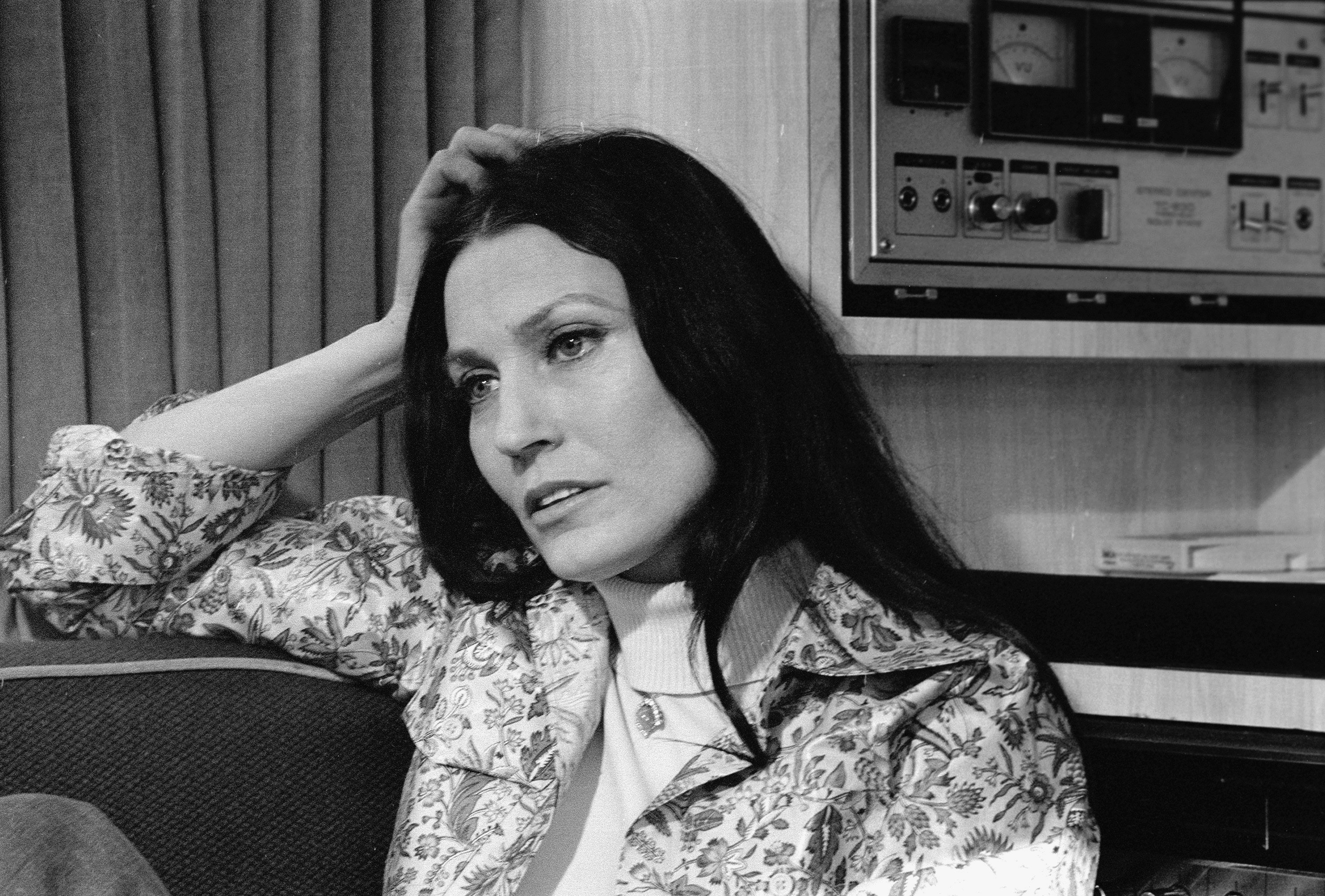 Loretta Lynn rests her head on her hand and reclines on a couch on February 24, 1975. | Source: Getty Images