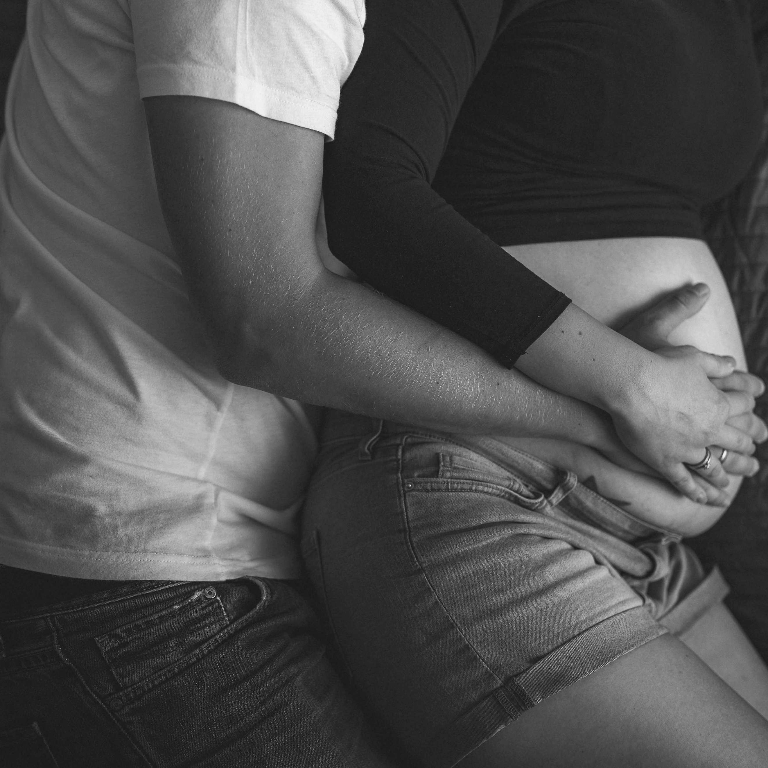 A man cuddling up to a pregnant woman in bed | Source: Pexels