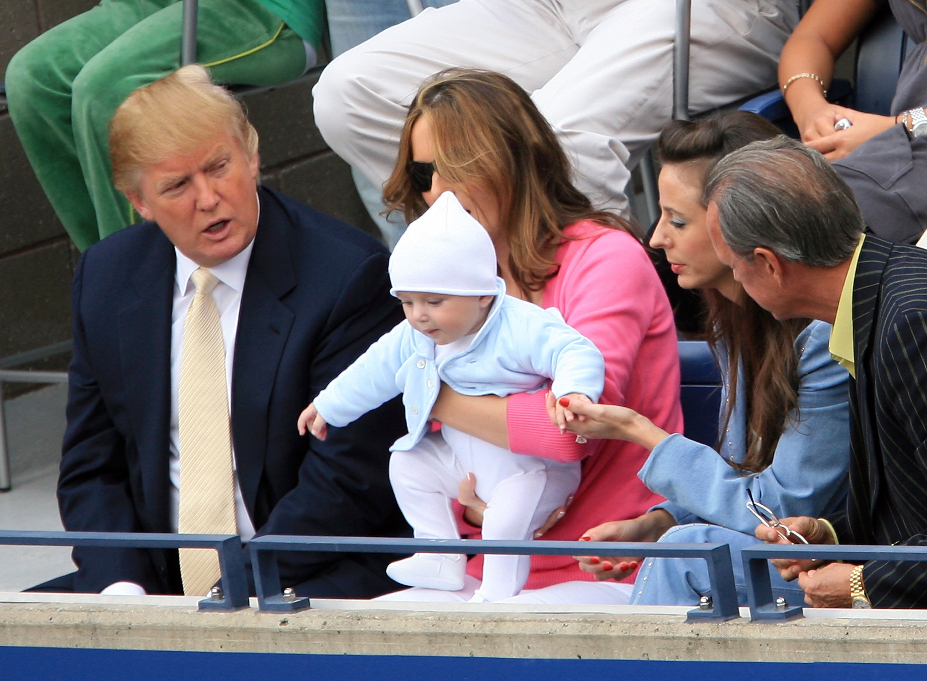 Courtside at the U.S. Open, Melania Trump holds baby Barron as Donald Trump looks on during the men’s final between Roger Federer and Andy Roddick.