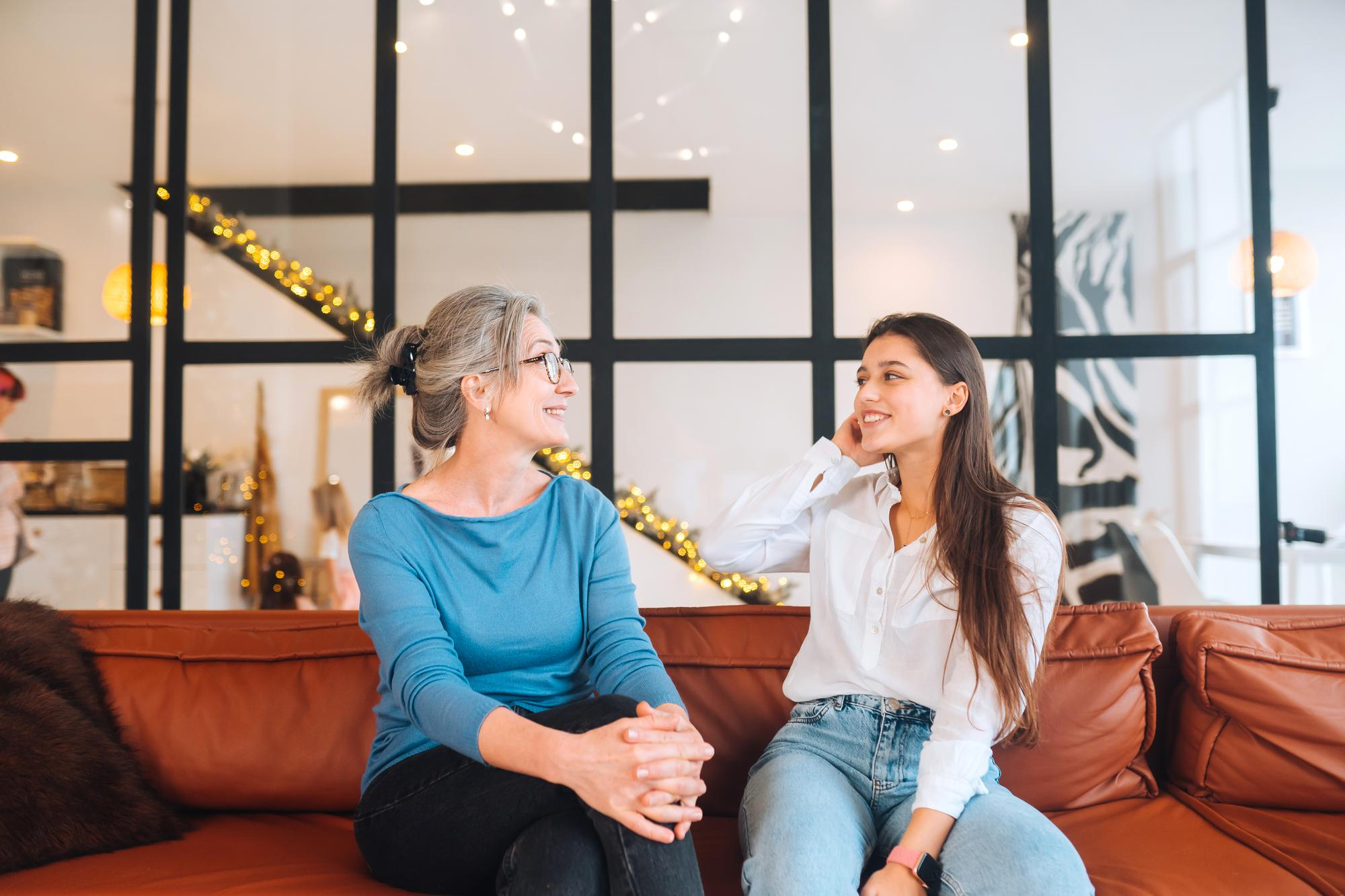 A mother-daughter duo talking while sitting on a sofa | Source: Freepik