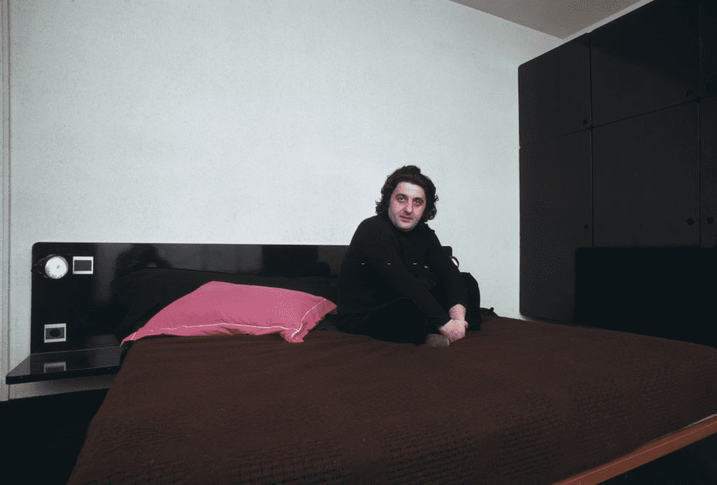 Le producteur de films français Jean-Pierre (1942-1985) assis dans une chambre, novembre 1974. | Photo : Getty Images