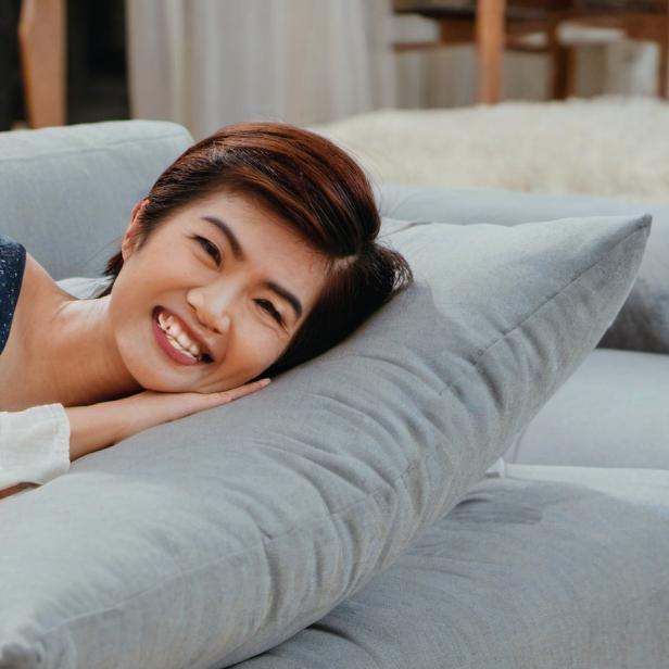 A woman lying happily on a sofa | Source: Midjourney