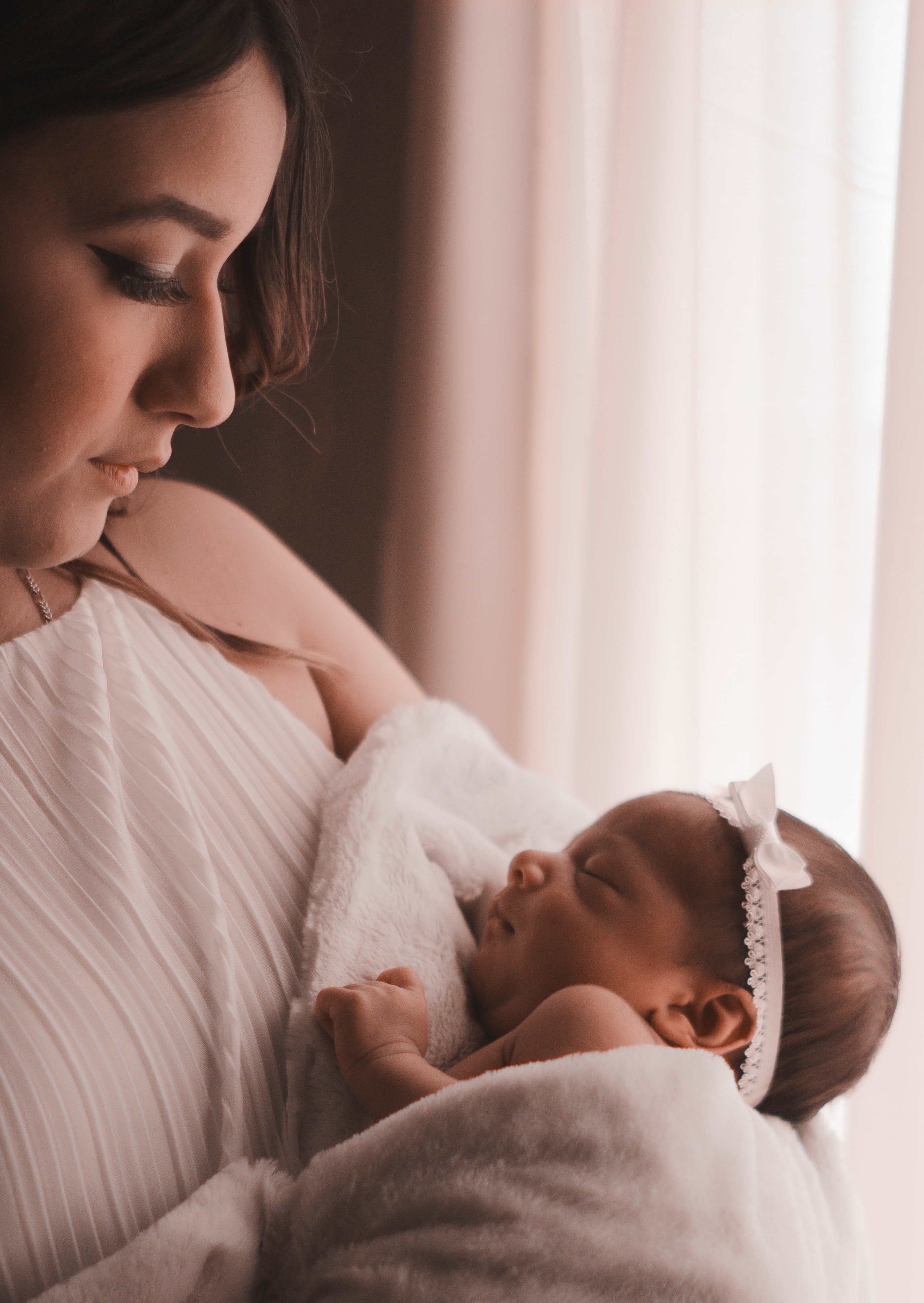 A recent mother holding her newborn and looking at the baby with affection. I Photo: Pexels.