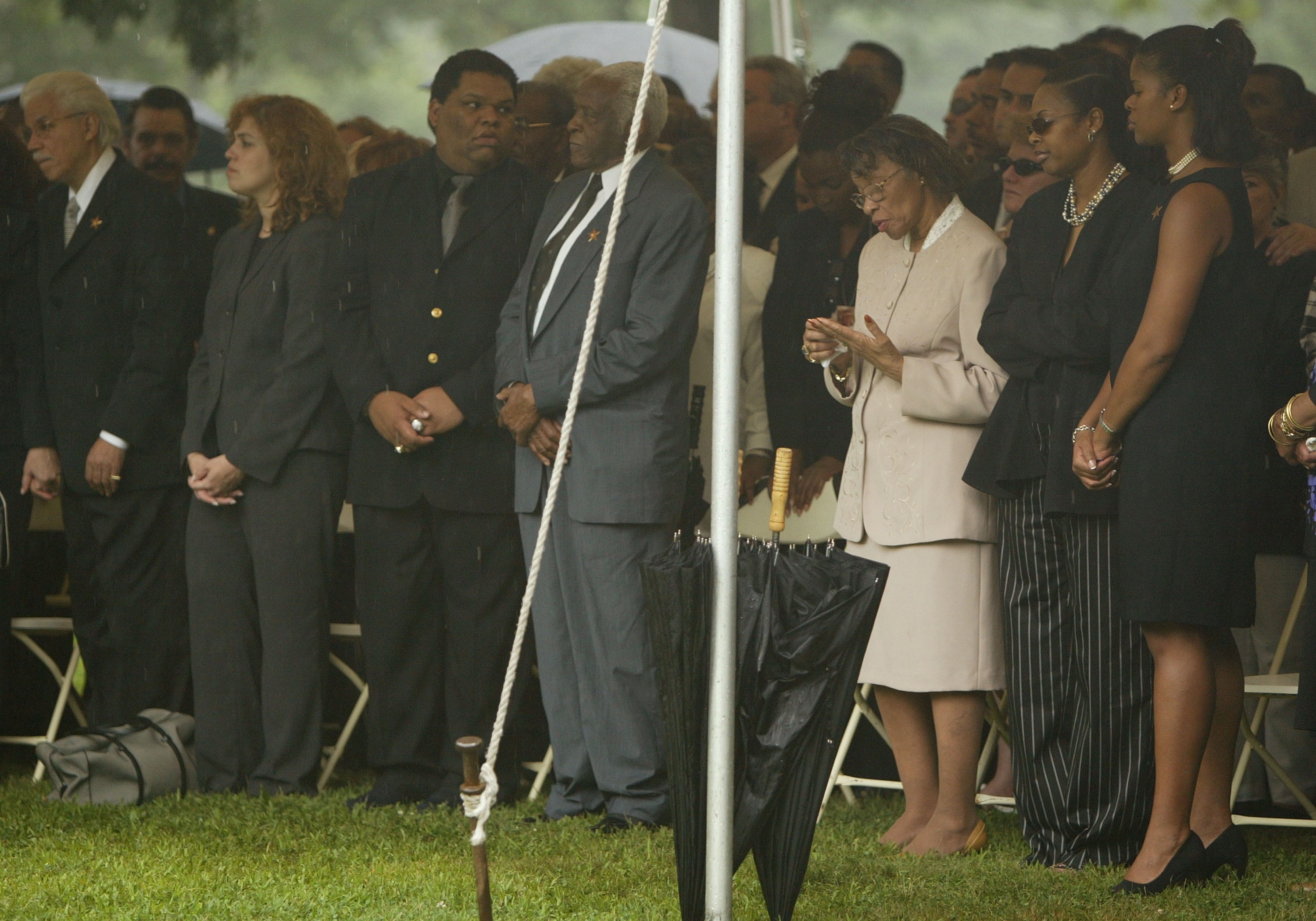 Pedro Knight, viudo de Celia Cruz, de pie junto a Gladys Bécquer (centro der.), hermana de Celia Cruz, en un tributo público en el Cementerio Woodlawn en julio de 2003 en el Bronx, Nueva York || Fuente: Getty Images Pedro Knight, viudo de Celia Cruz, de pie junto a Gladys Bécquer (centro der.), hermana de Celia Cruz, en un tributo público en el Cementerio Woodlawn en julio de 2003 en el Bronx, Nueva York || Fuente: Getty Images