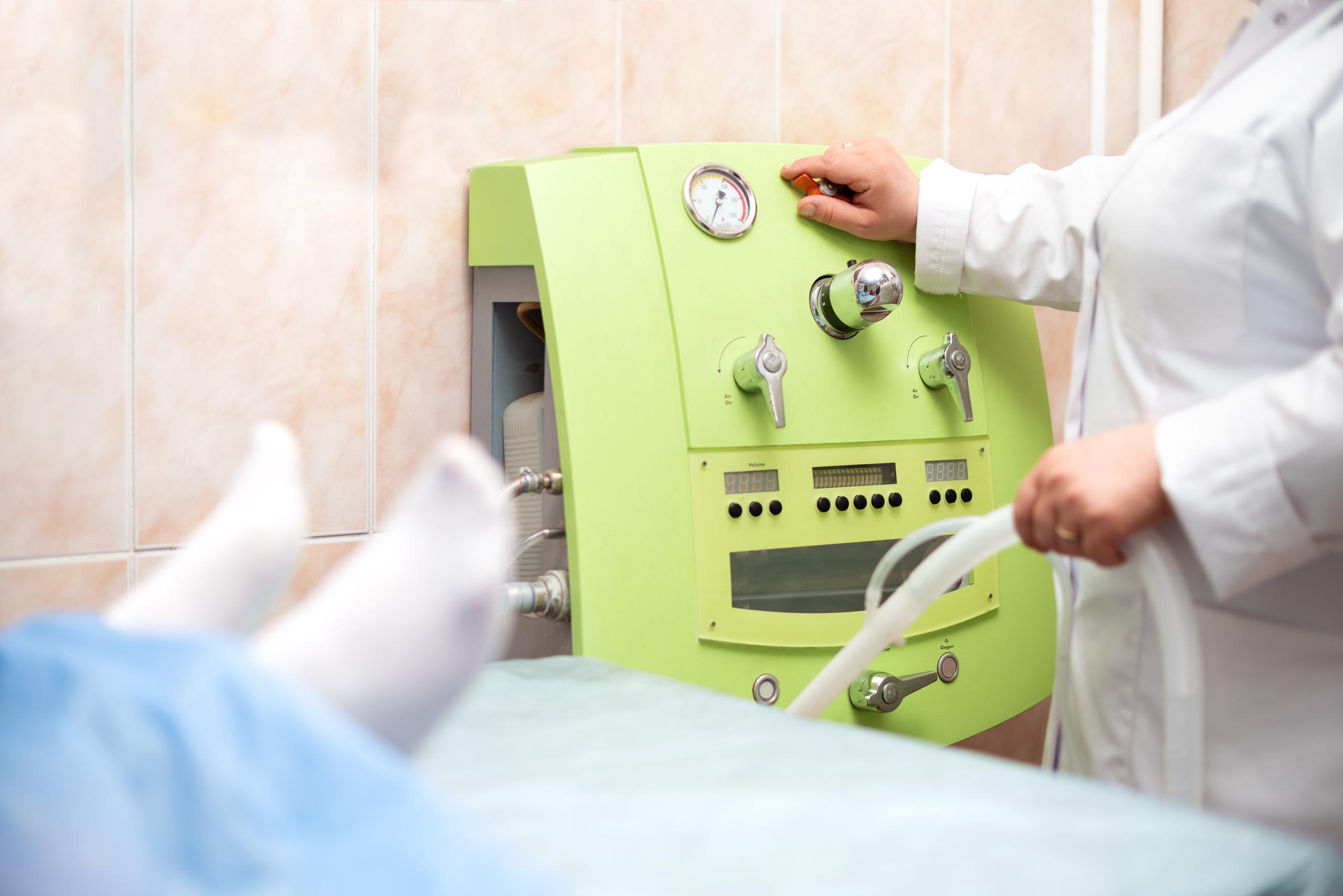 A doctor operating a colon cleansing machine | Source: Getty Images