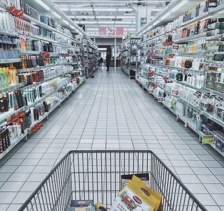 Una persona caminando por el pasillo de un supermercado mientras hace sus compras. | Foto: Pexels