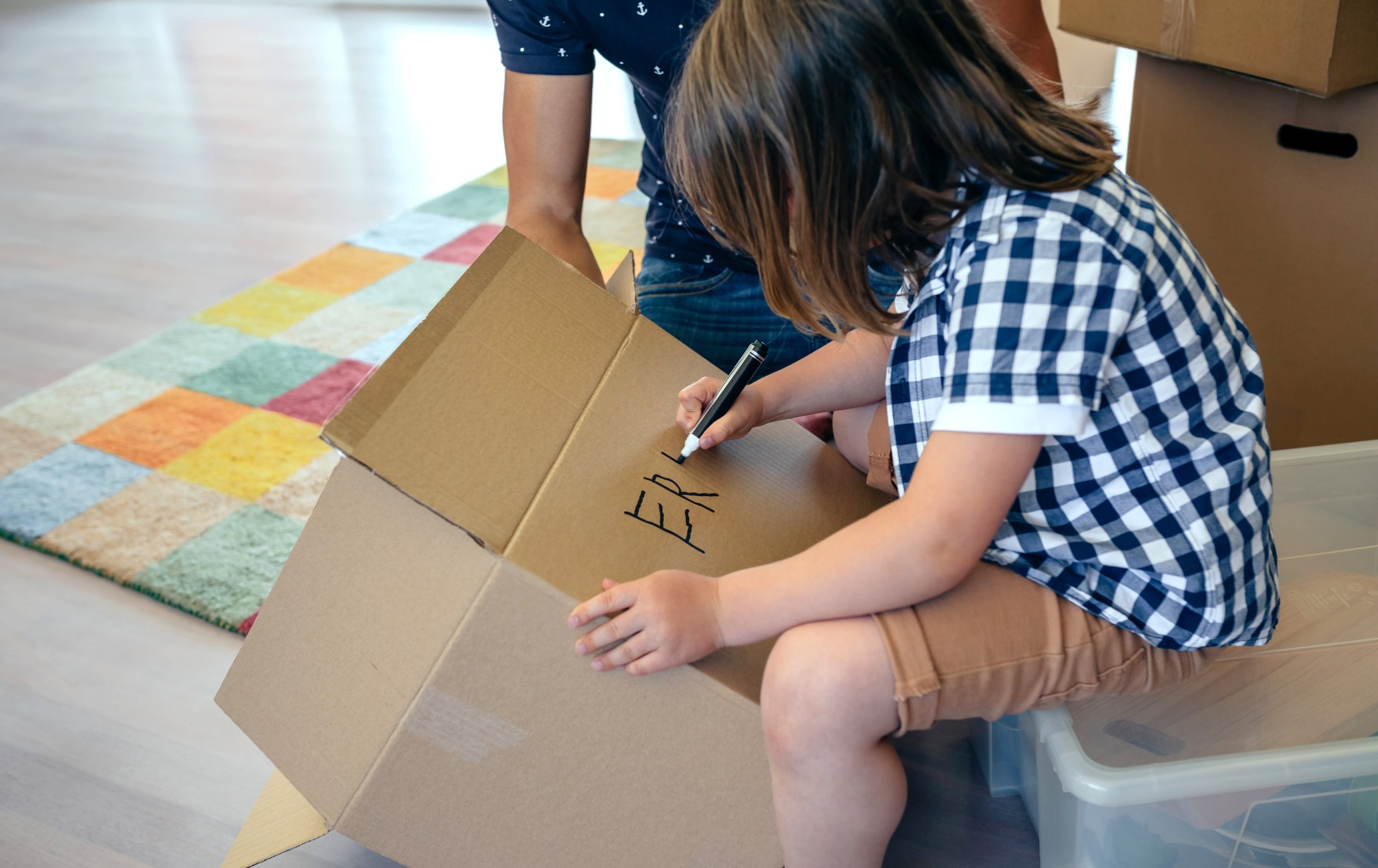 Ein Junge schreibt seinen Namen auf eine Schachtel. I Quelle: Getty Images