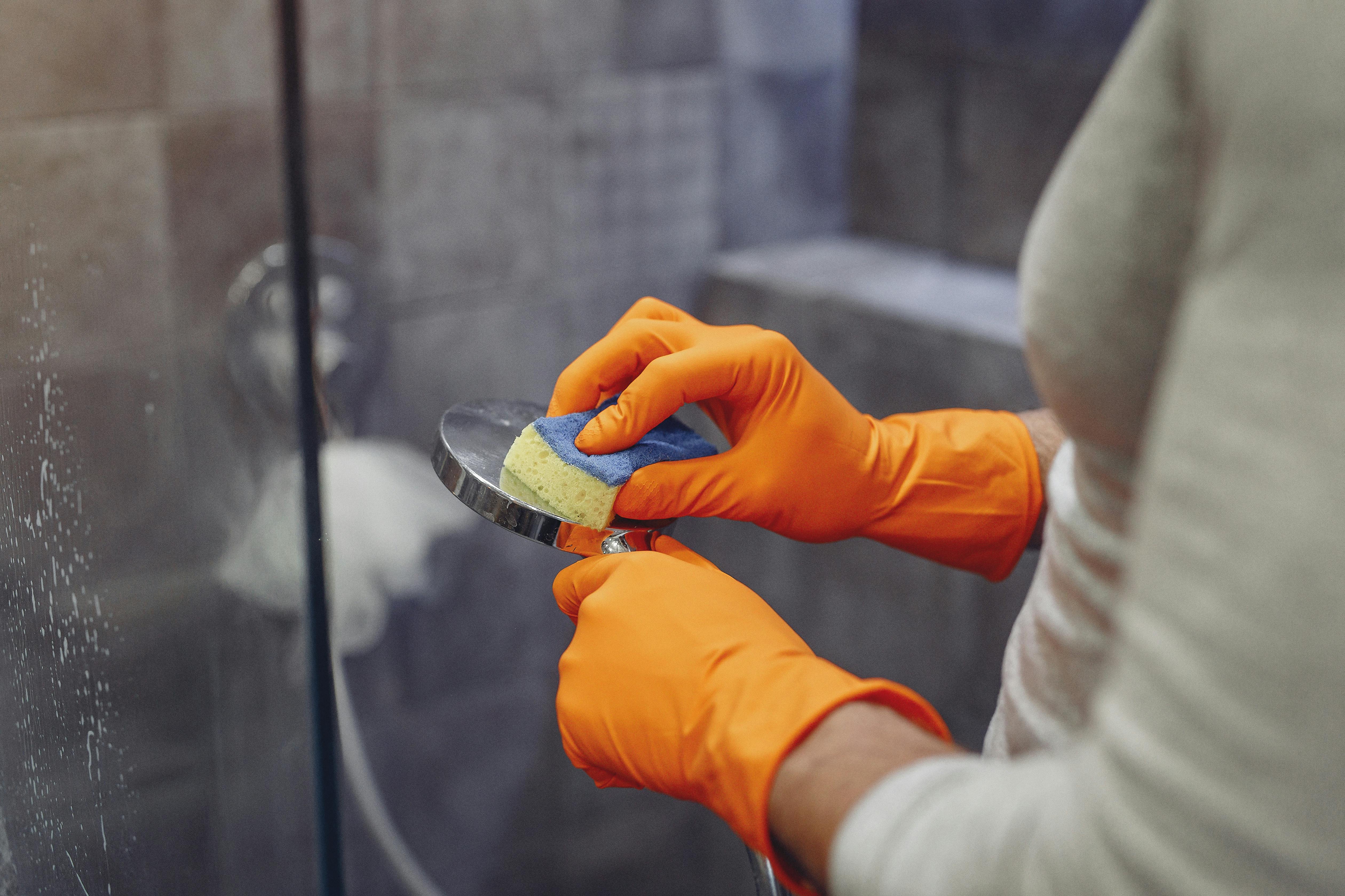 A person cleaning a shower head thoroughly | Source: Pexels