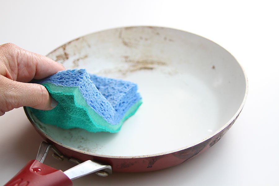 Les mains d'une personne lavant une casserole avec une éponge. | Flickr Les mains d'une personne lavant une casserole avec une éponge. | Flickr