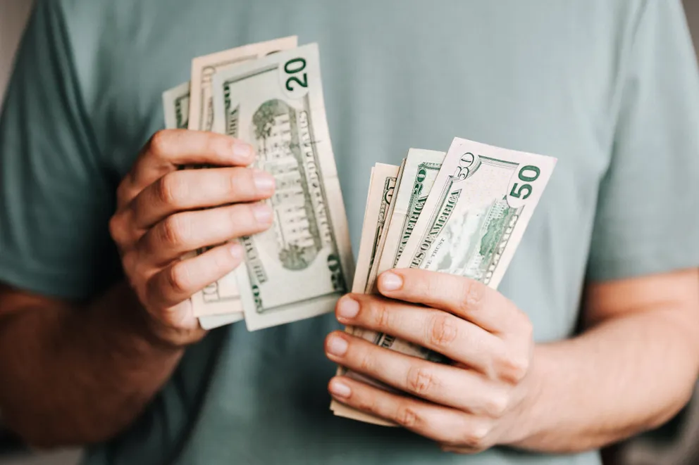 Der junge Mann mit einer Hand voll Geld. | Quelle: Pixabay