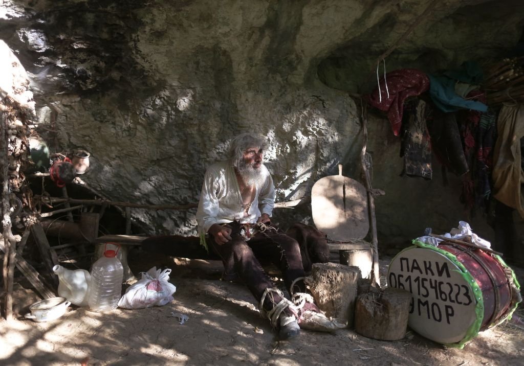 L'ermite serbe Panta Petrovic pose devant sa grotte dans la ville de Pirot, dans le sud de la Serbie, le 9 août 2021. | Photo : Getty Images