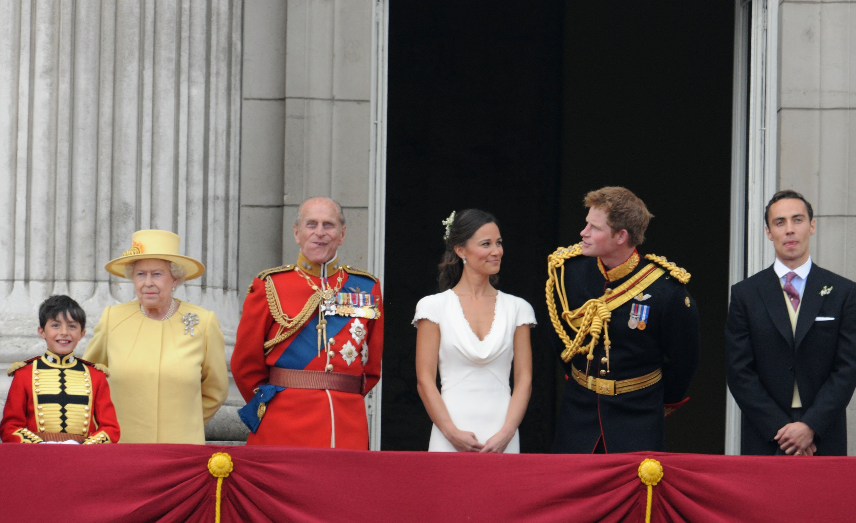 (L-R) Master William Lowther-Pinkerton, Queen Elizabeth II, Prince Philip, Pippa Middleton, Prince Harry and James Middleton look at the crowds from the balcony of Buckingham Palace following a royal wedding on April 29, 2011 in London, England ┃Source: Getty Images