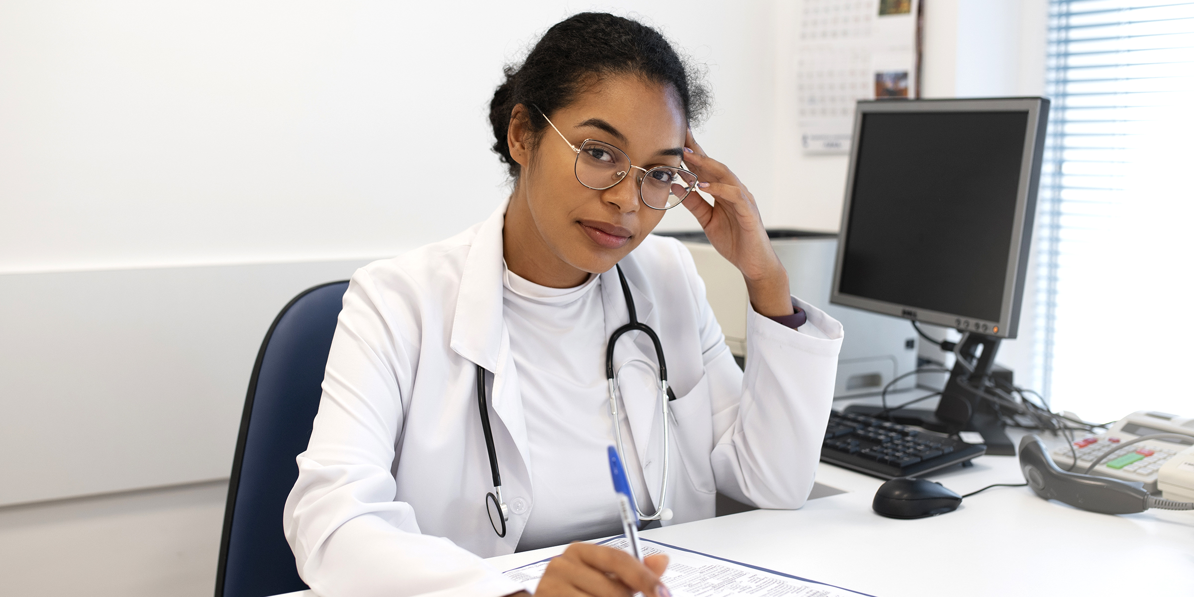 A doctor sitting at her desk | Source: Freepik