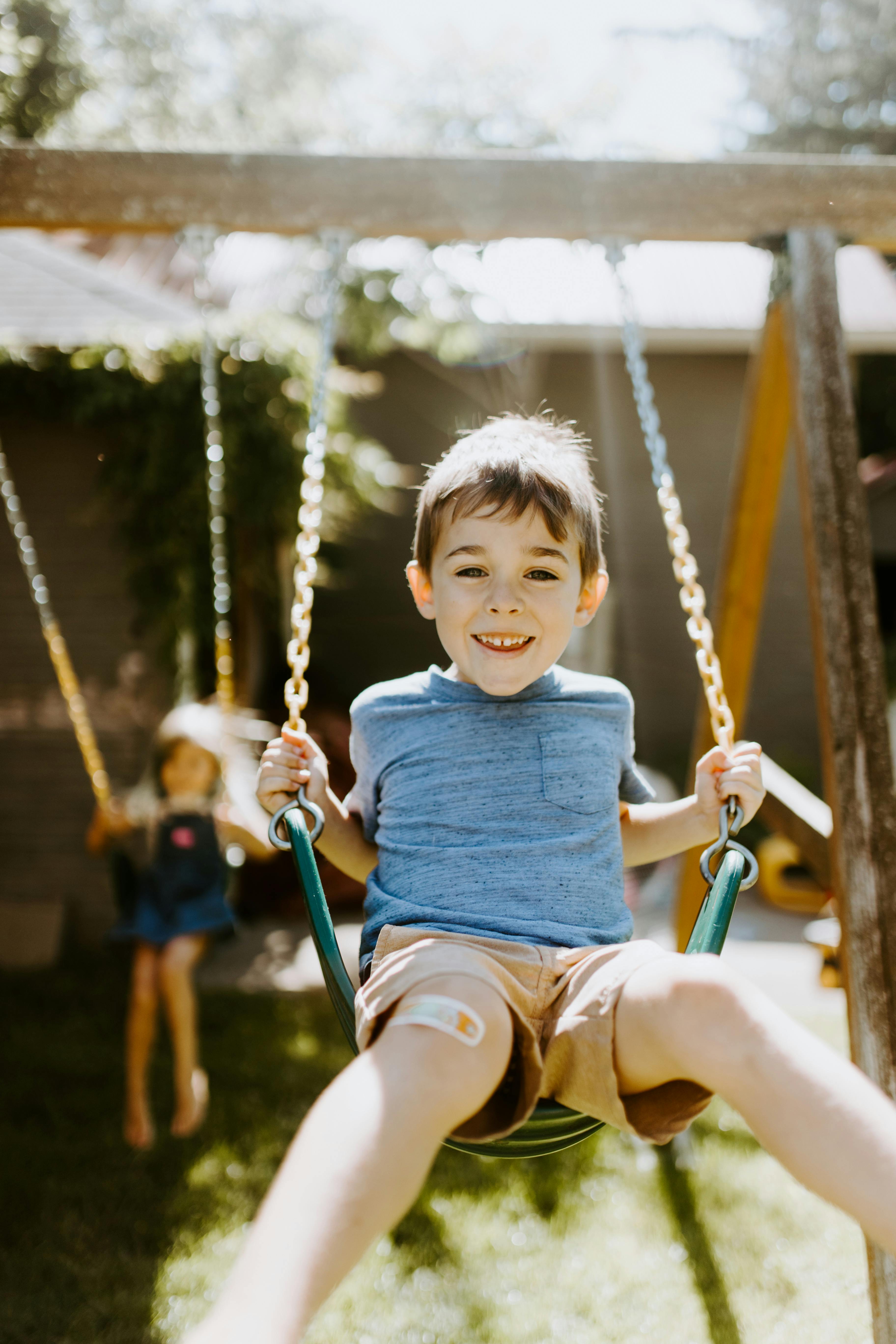 Happy little boy on a swing | Source: Pexels