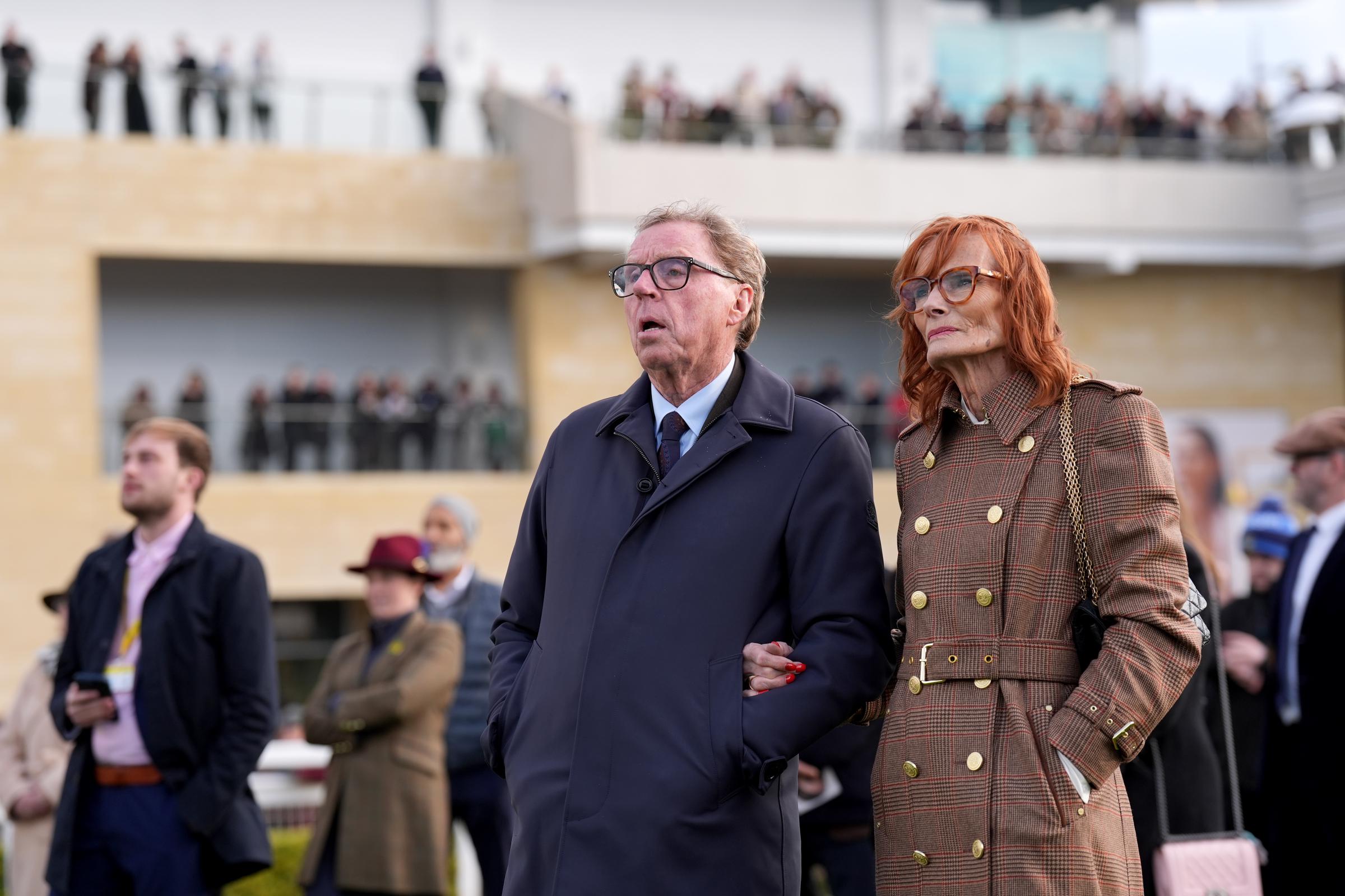 Harry and Sandra Redknapp were seen on Day 4 of the Cheltenham Festival on 13 March 2026, standing side by side as they watched the racing unfold, both dressed in tailored coats suited to the brisk conditions — a composed and attentive moment that captured their shared interest in the sport and their continued presence together at key racing events.