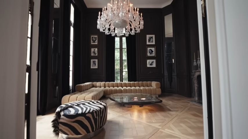 The dark, moody walls of the petit salon are adorned with beautifully framed black-and-white portraits of Lenny's mother, Roxie Roker. | Source: YouTube/@Archdigest
