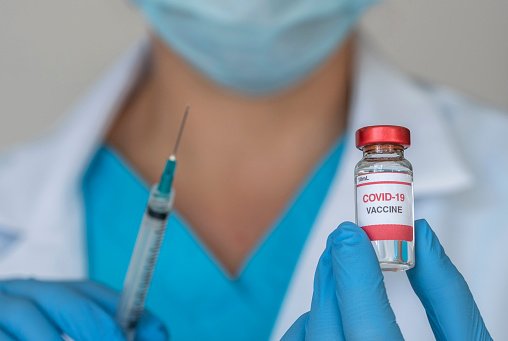 Médecins tenant le vaccin Covid-19 et la seringue. | Photo : Getty Images
