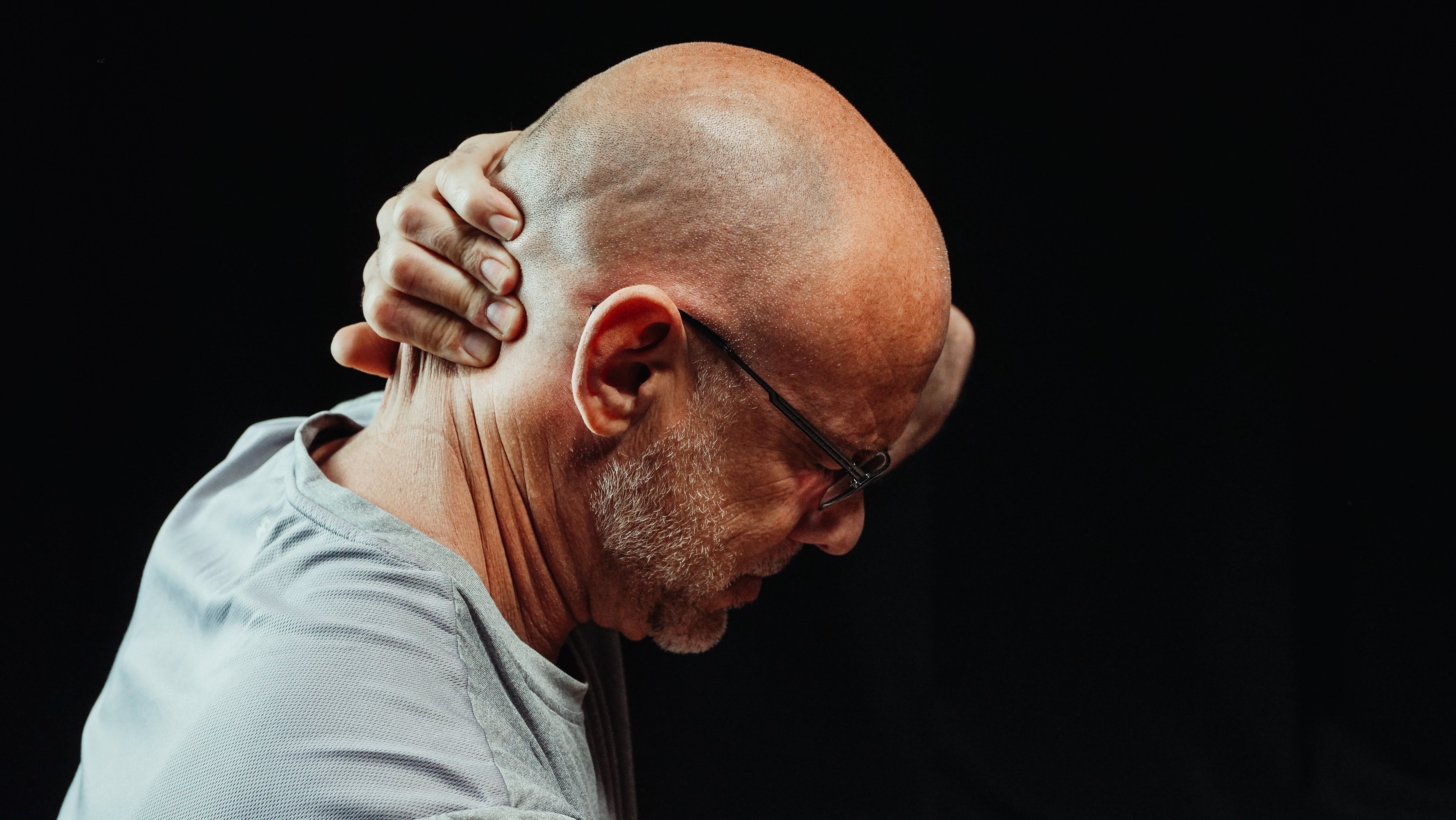 A man experiencing neck pain. | Source: Pexels