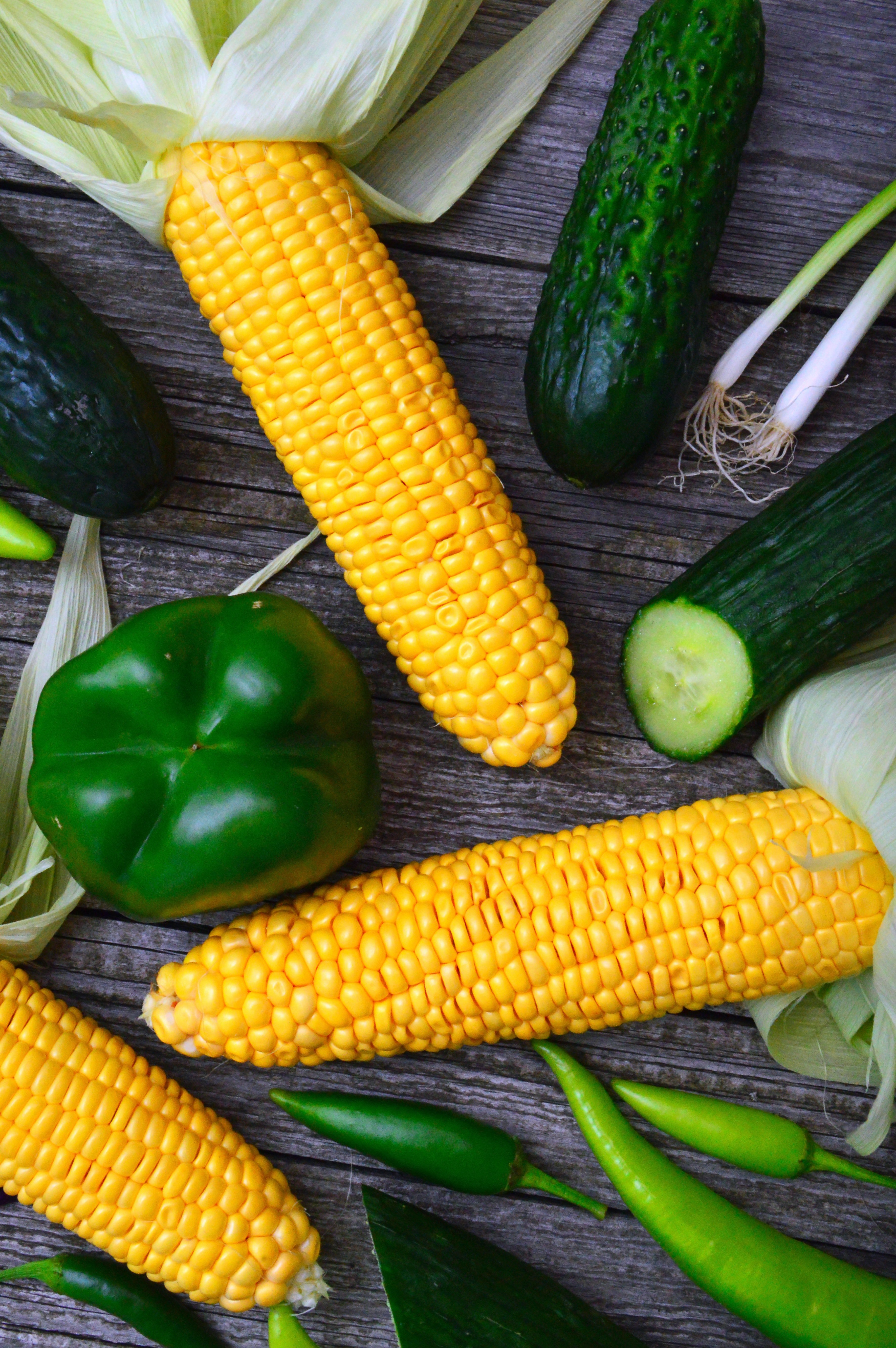 Corn and cucmbers lying on a table. | Pexles/ Adonyi Gábor