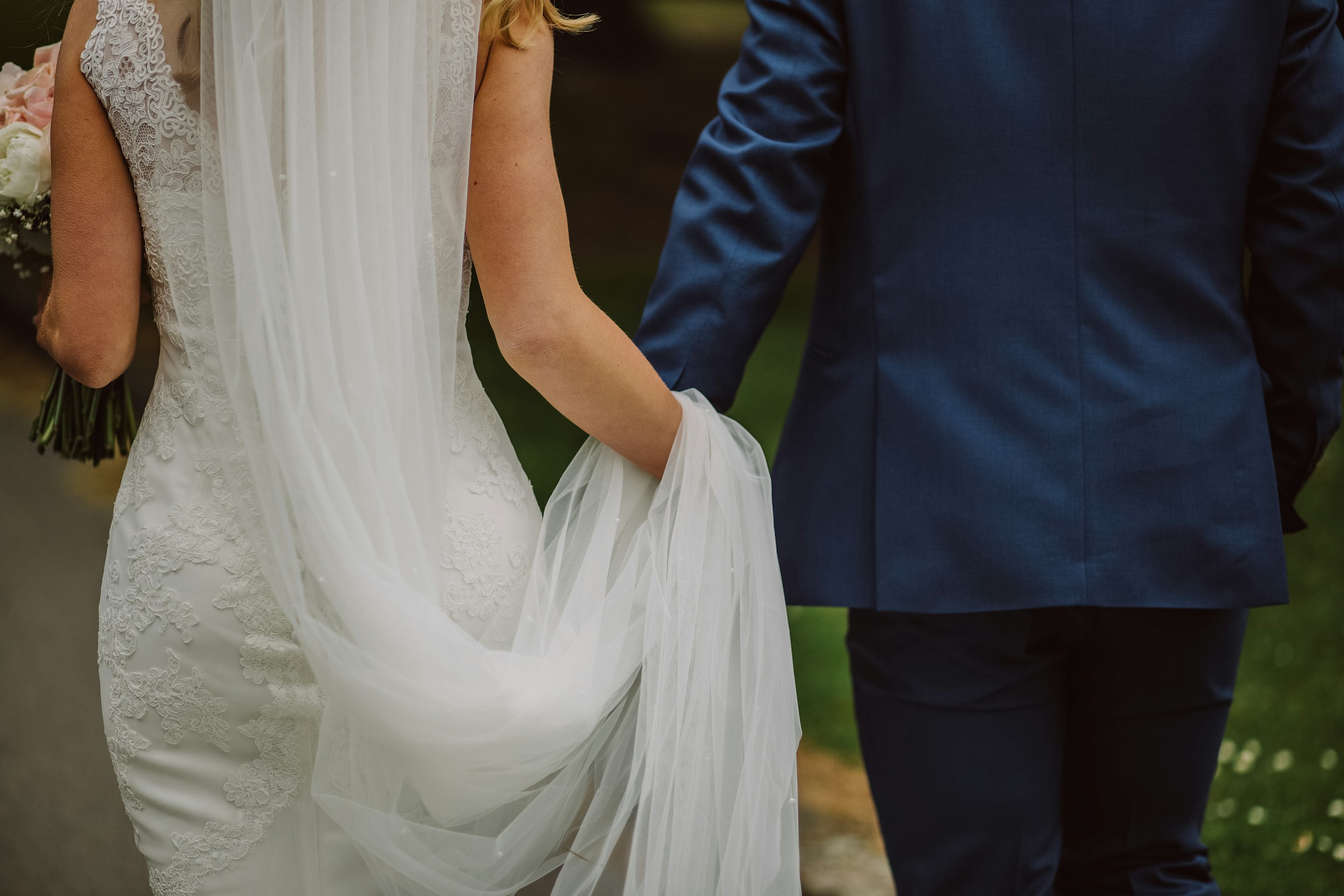 A newlywed couple holding hands and walking together | Source: Unsplash