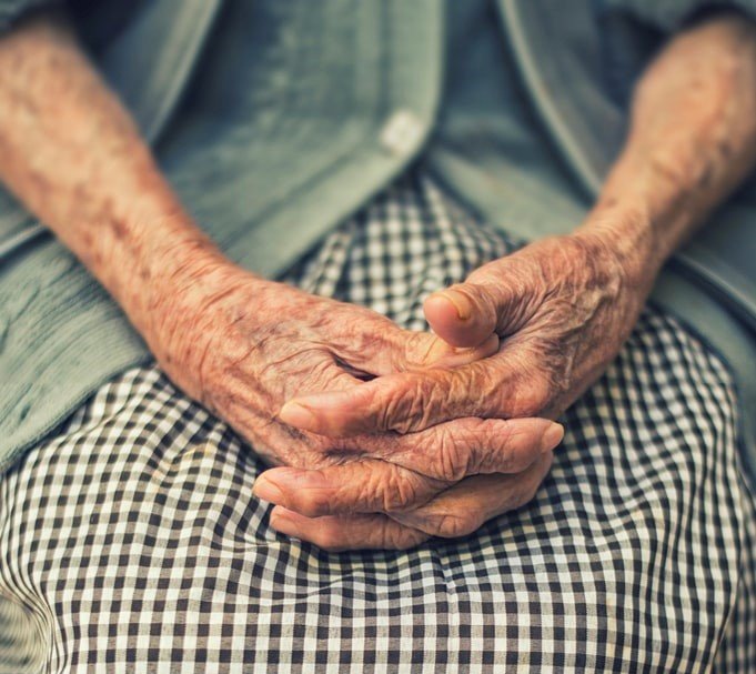 Una anciana sentada con las manos juntas. | Foto: Unsplash
