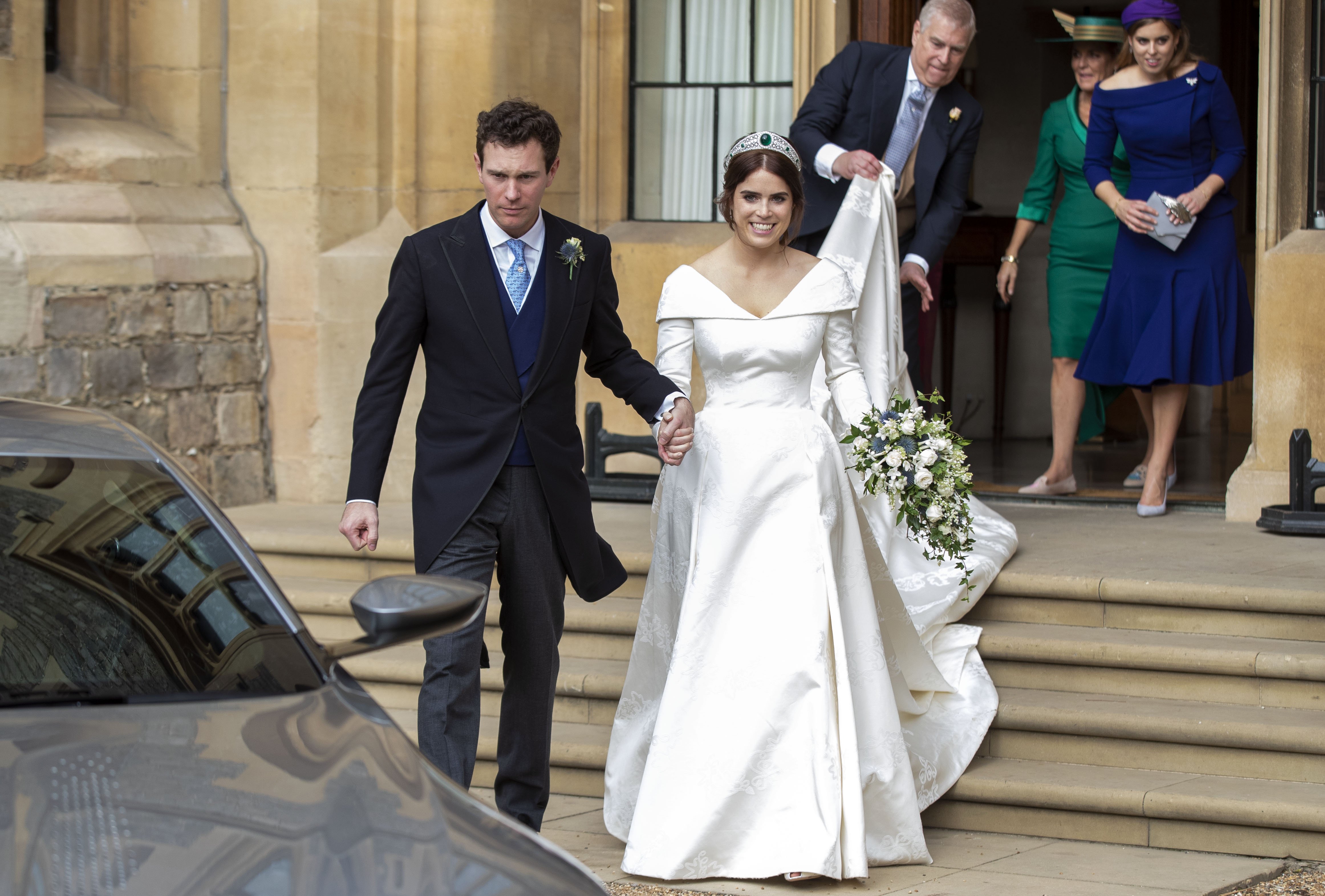 Princess Eugenie and Jack Brooksbank helped by Princess Beatrice and Prince Andrew, Duke of York leave Windsor Castle in an Aston Martin DB10 after their wedding for an evening reception at Royal Lodge on October 12, 2018 in Windsor, England. | Source: Getty Images