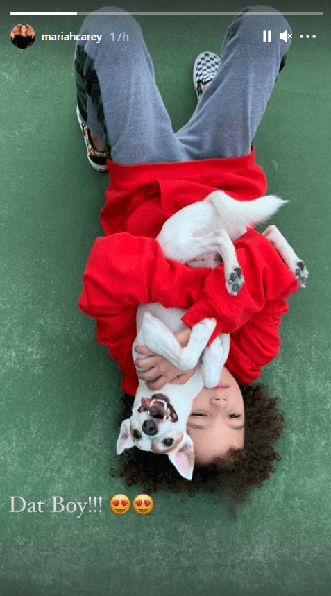 Mariah Carey's son Moroccan hugs his dog while wearing a red sweater | Photo: Instagram/mariahcarey
