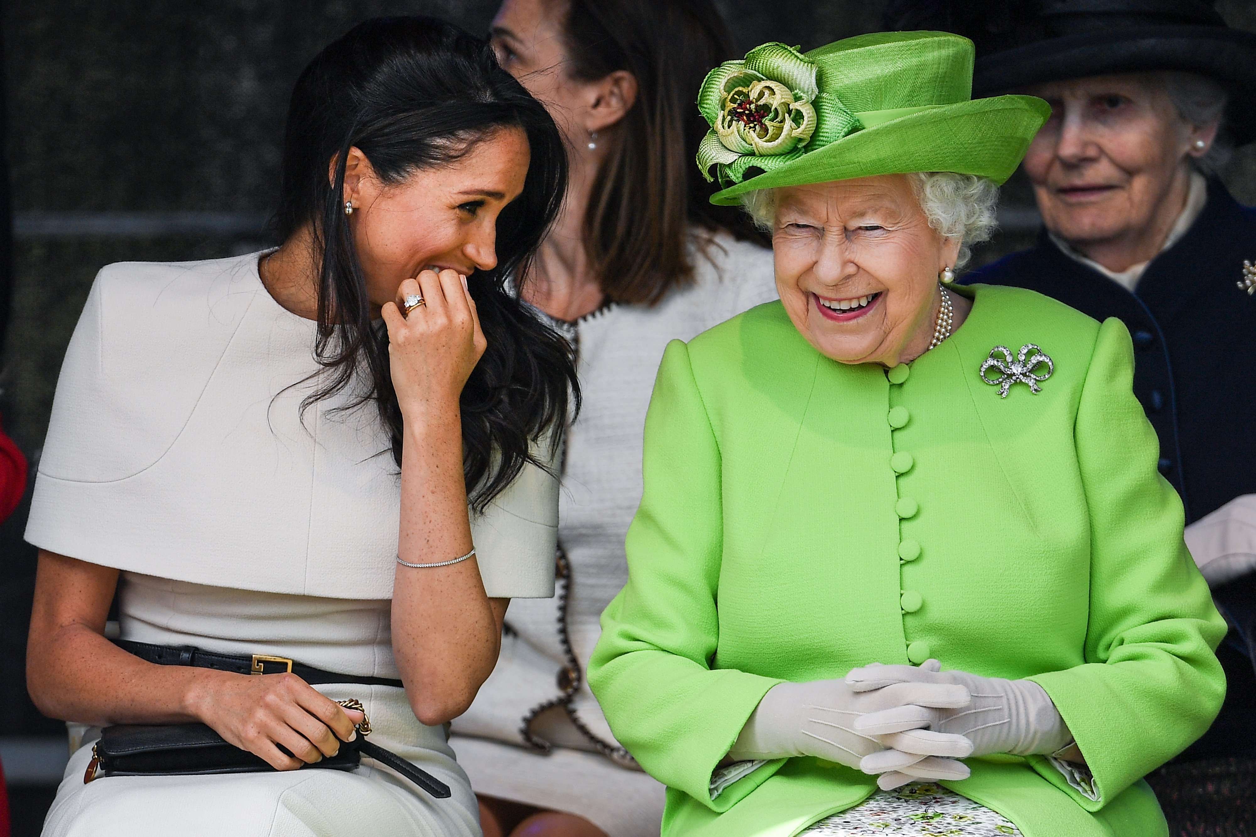 Queen Elizabeth II pictured sitting and laughing with Meghan, Duchess of Sussex during a ceremony to open the new Mersey Gateway Bridge on June 14, 2018 in Halton, Cheshire, England. / Source: Getty Images