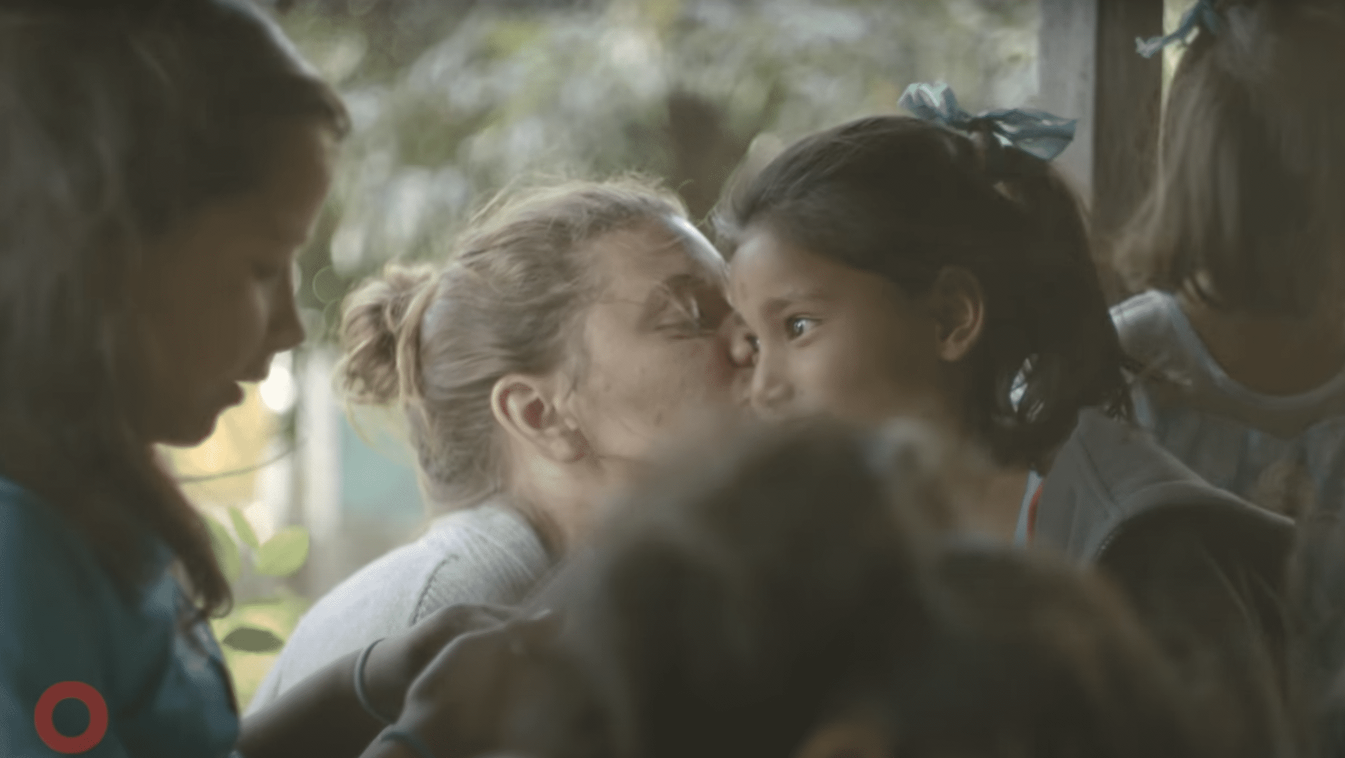 Maggie Doyne pictured kissing one of her adopted kids. | Source: YouTube.com/Global Citizen