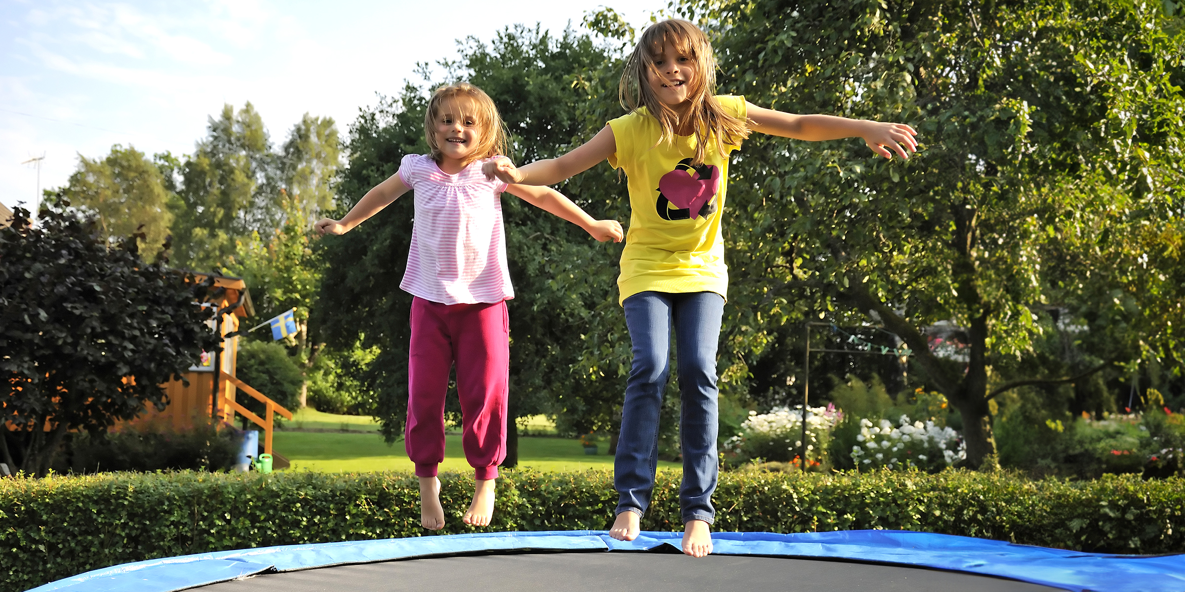 Two kids jumping on a trampoline | Source: Shutterstock