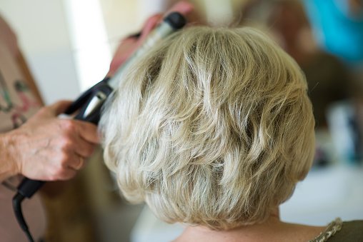 Image recadrée de la coiffure d'un client dans un salon de coiffure. | Photo : Getty Images