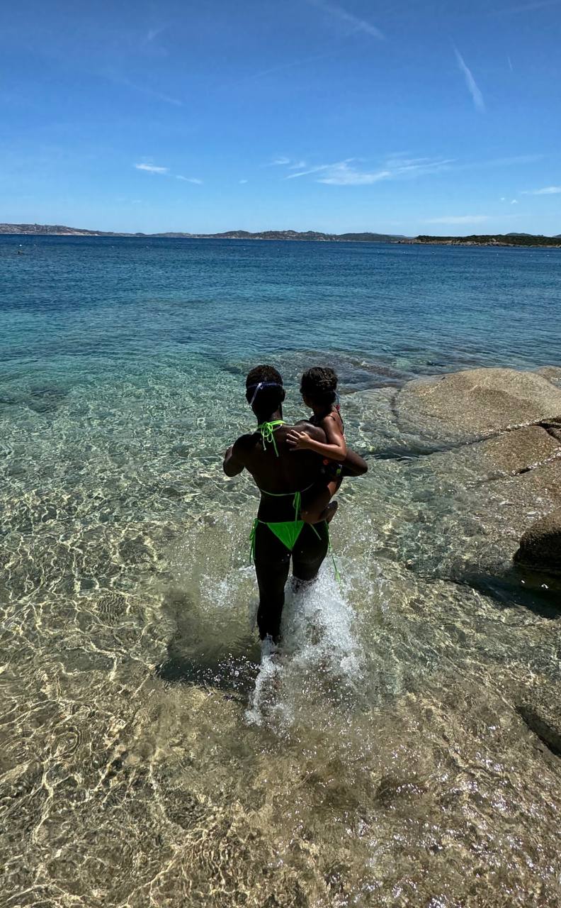 Jodie Turner-Smith carries Juno Jackson into the water on a clear beach day | Source: Instagram/jodiesmith