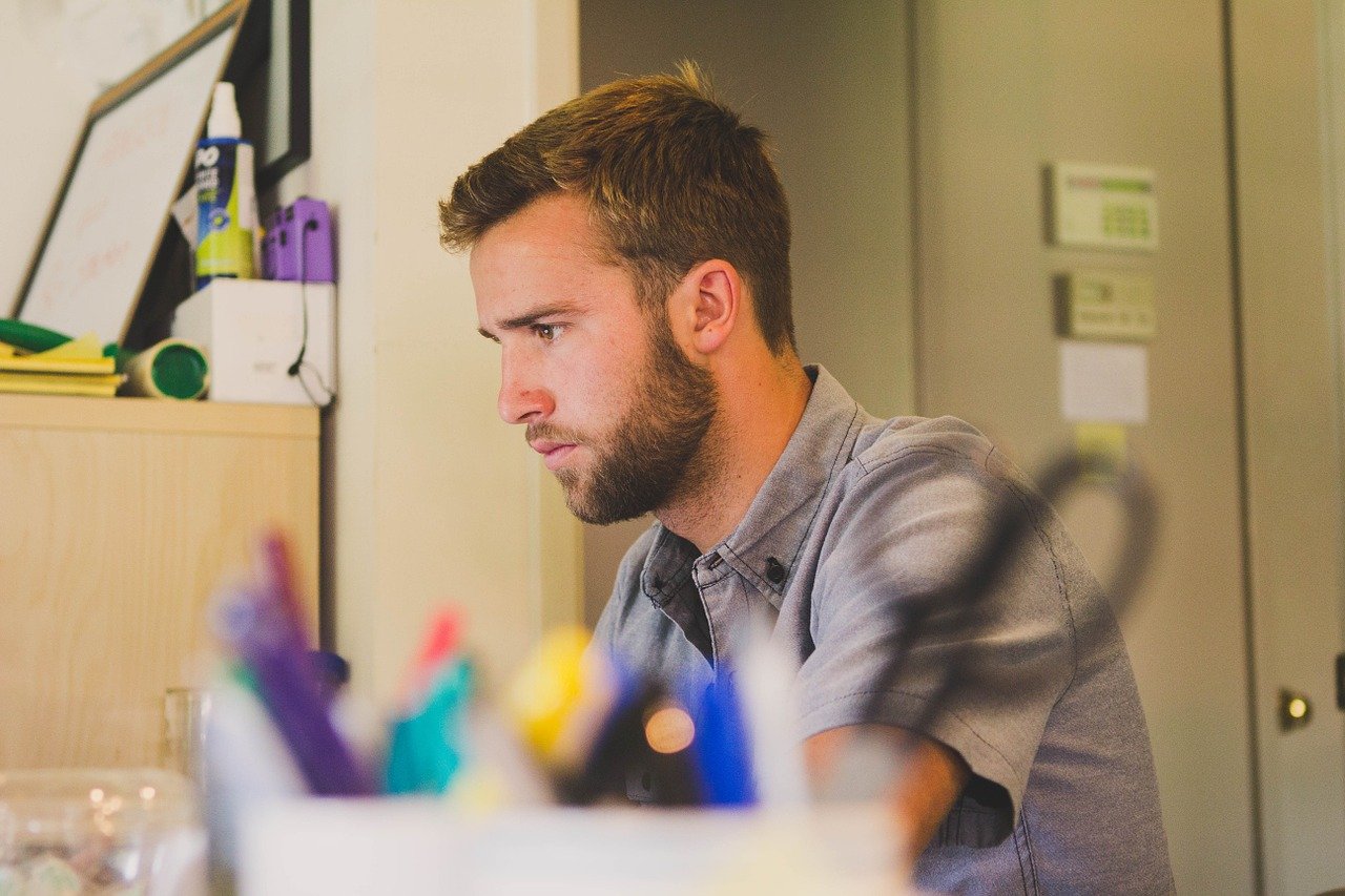 A young office worker busy by his desk. I Image: Pixabay.