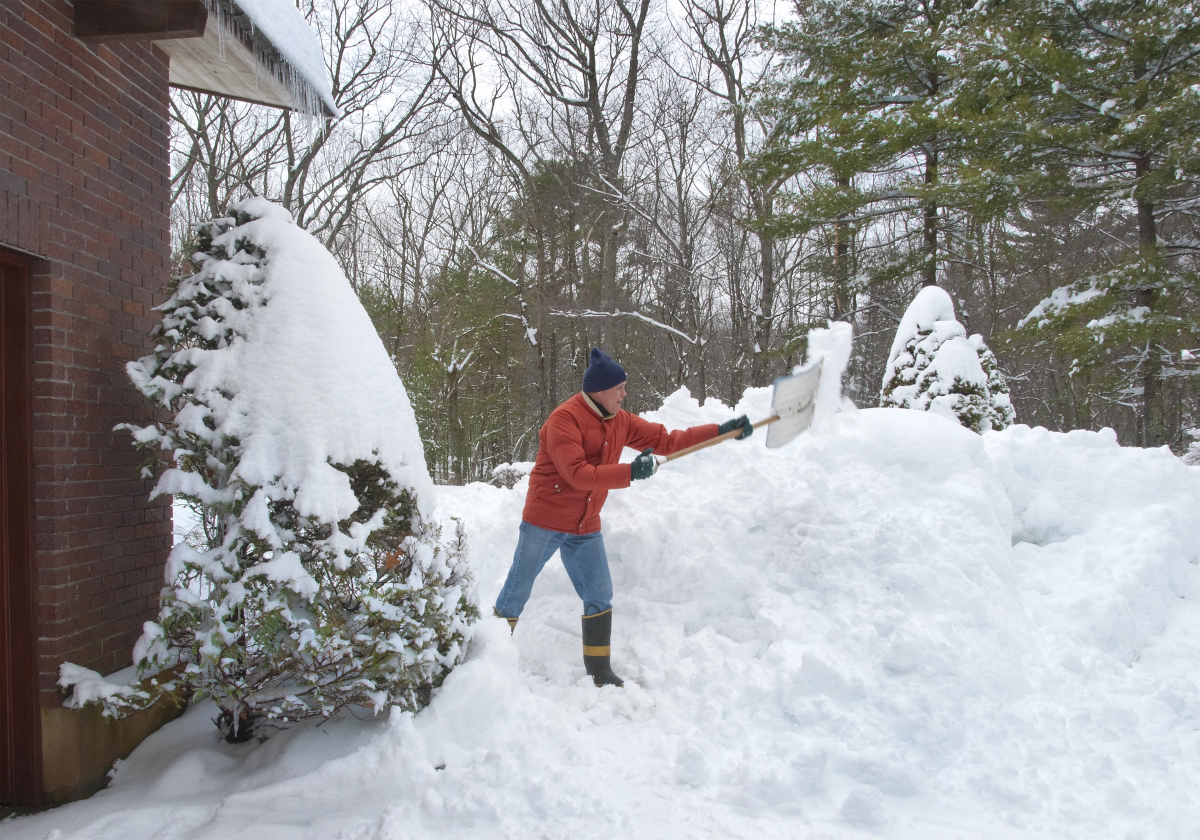 A senior citizen shoveling his walkway after heavy snowfall | Source: Shutterstock