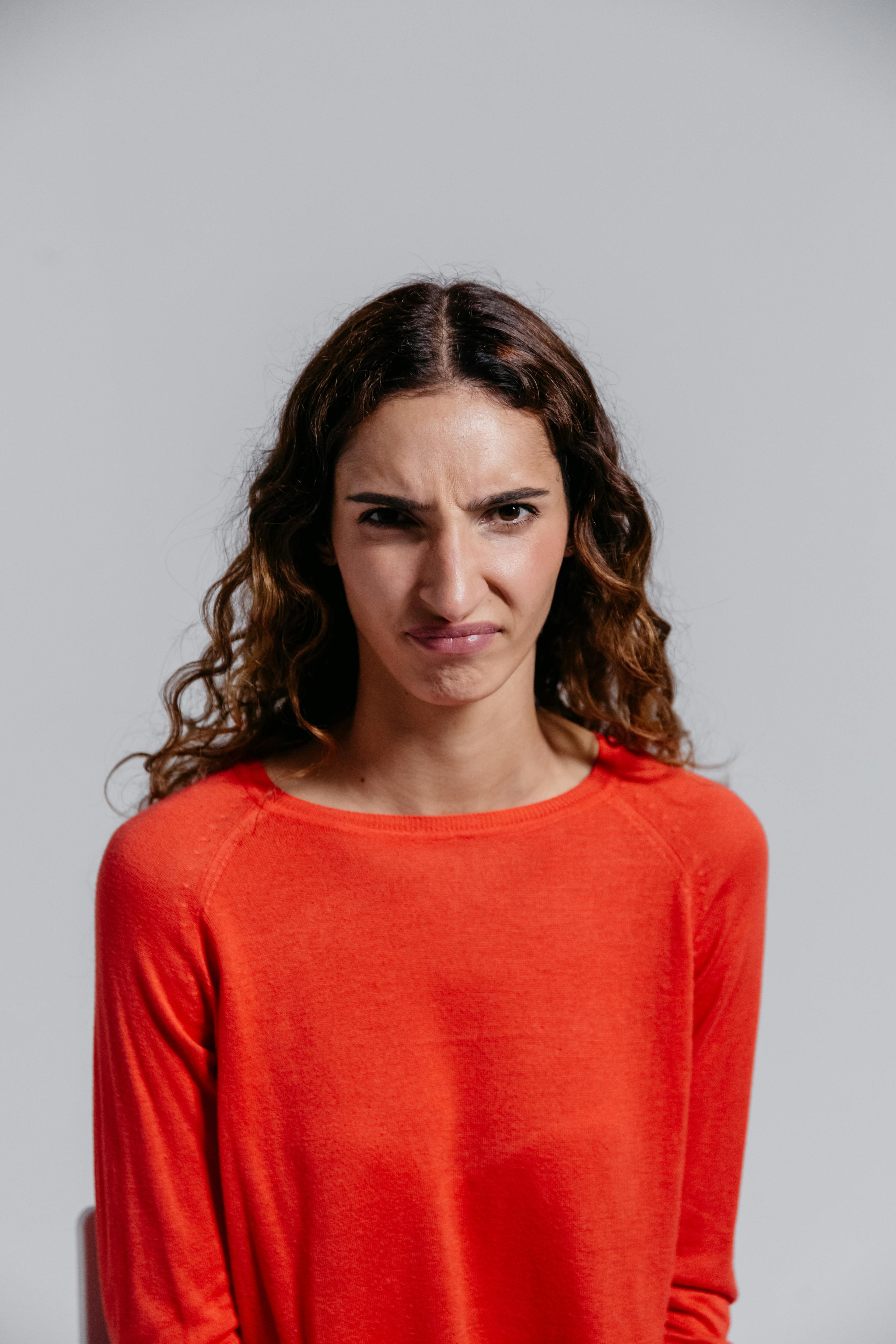 An angry woman in red looking at the camera | Source: Pexels