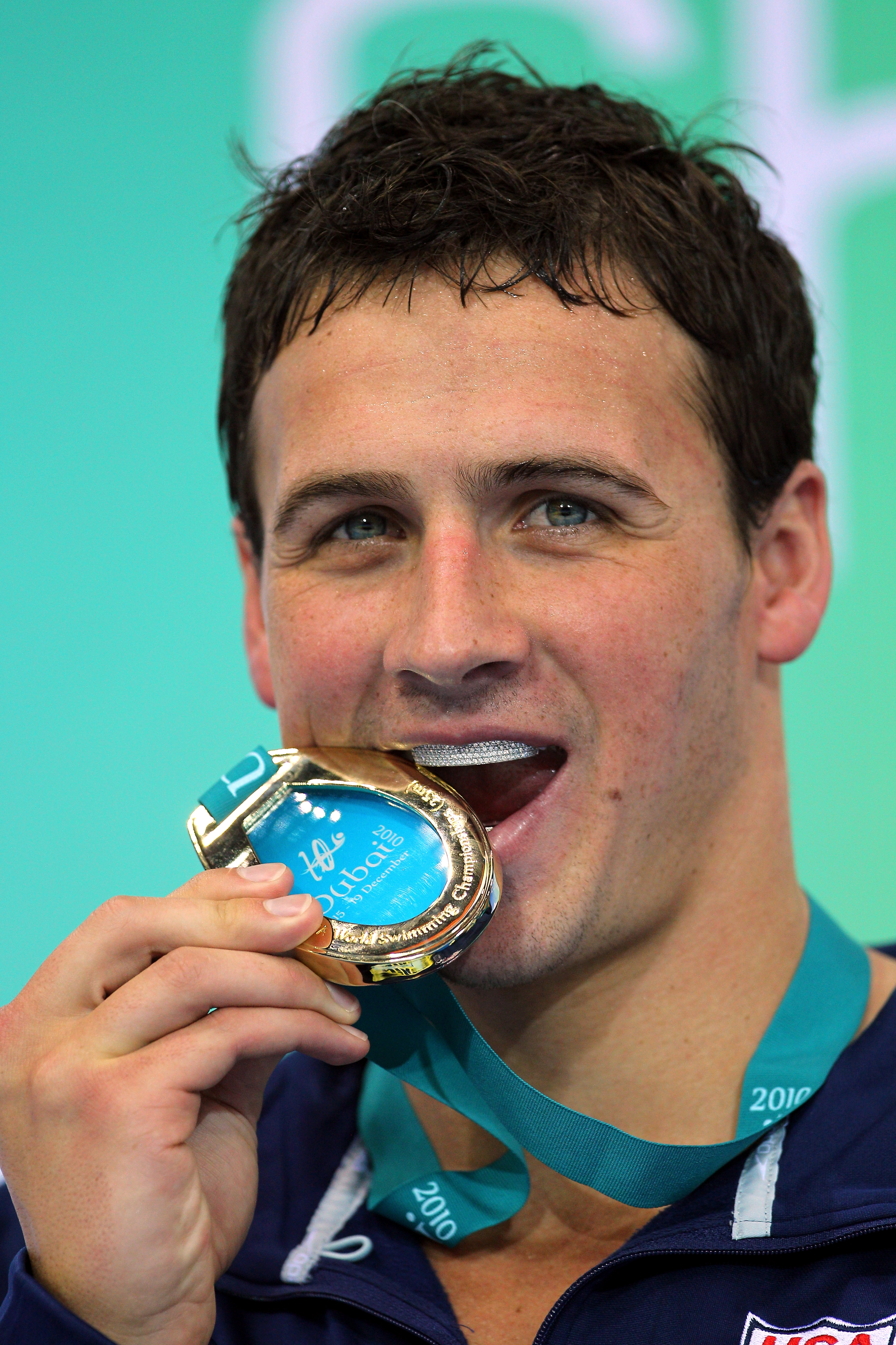 Ryan Lochte celebrates his latest triumph by biting his gold medal after winning the men’s 200m individual medley at the world championships in Dubai. Water droplets are still visible on his face as he grins proudly for the camera.