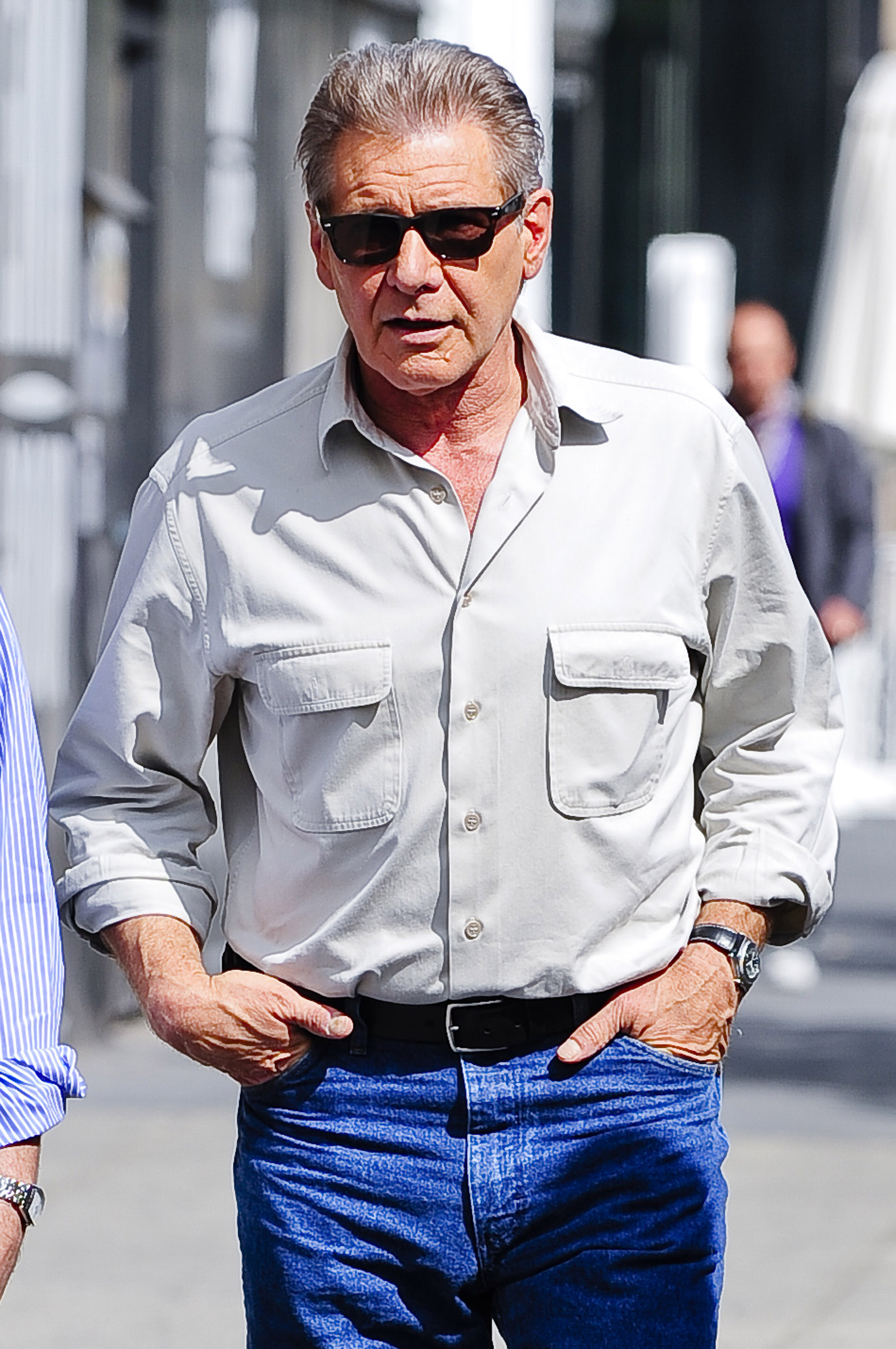 Ford keeps his hands in his pockets as he walks through New York City's Meatpacking District to the set of his film, "Morning Glory." The actor wore a relaxed, light gray button-down shirt with utility chest pockets, paired with classic blue jeans, a black leather belt, and dark sunglasses. | Source: Getty Images