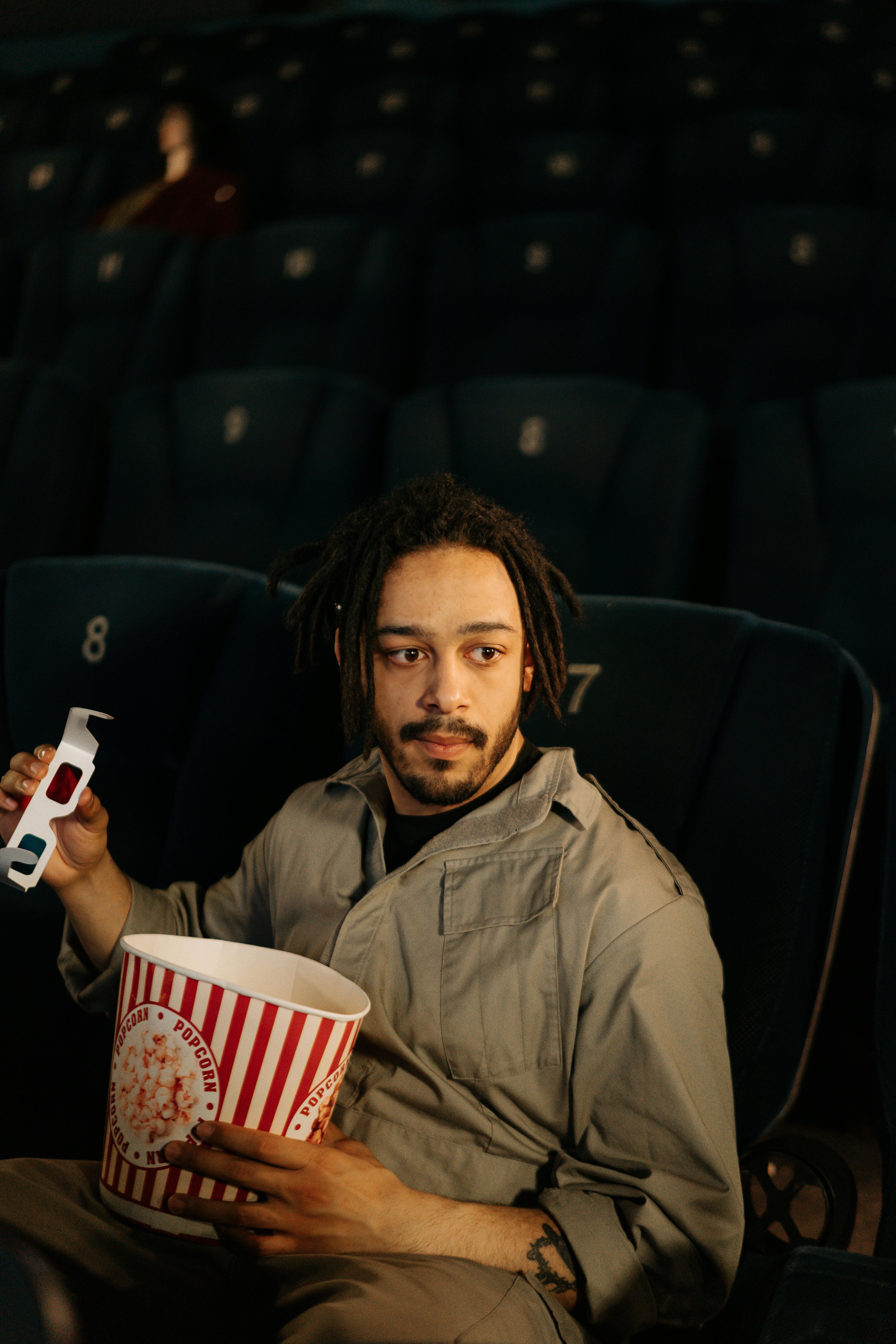 A man holding a bucket of popcorn | Source: Pexels