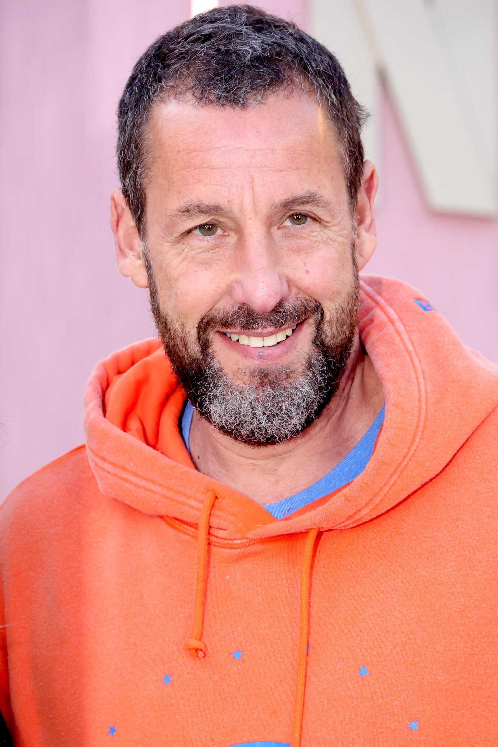 Adam Sandler smiles at a public event. The actor and comedian officiated Taylor Swift and Travis Kelce's wedding ceremony. | Source: Getty Images