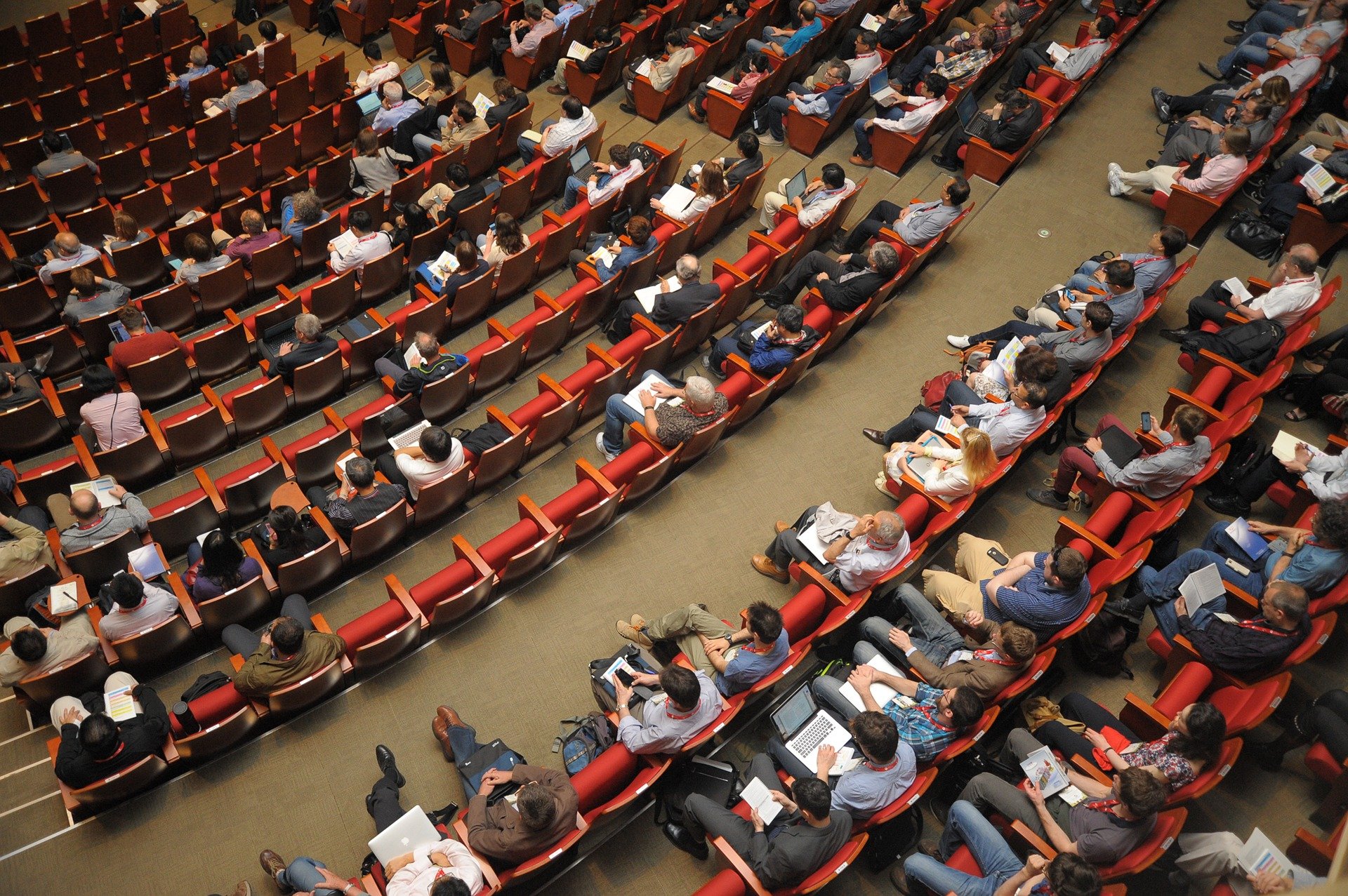 Several people sitting in an auditorium while attending a conference | Photo: Pixabay/정훈 김