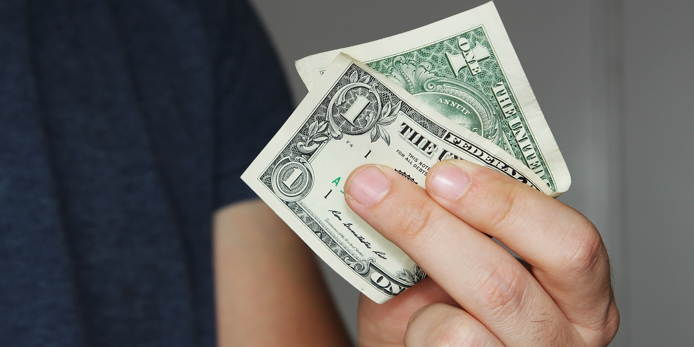 A person holding a $1 bill | Source: Shutterstock