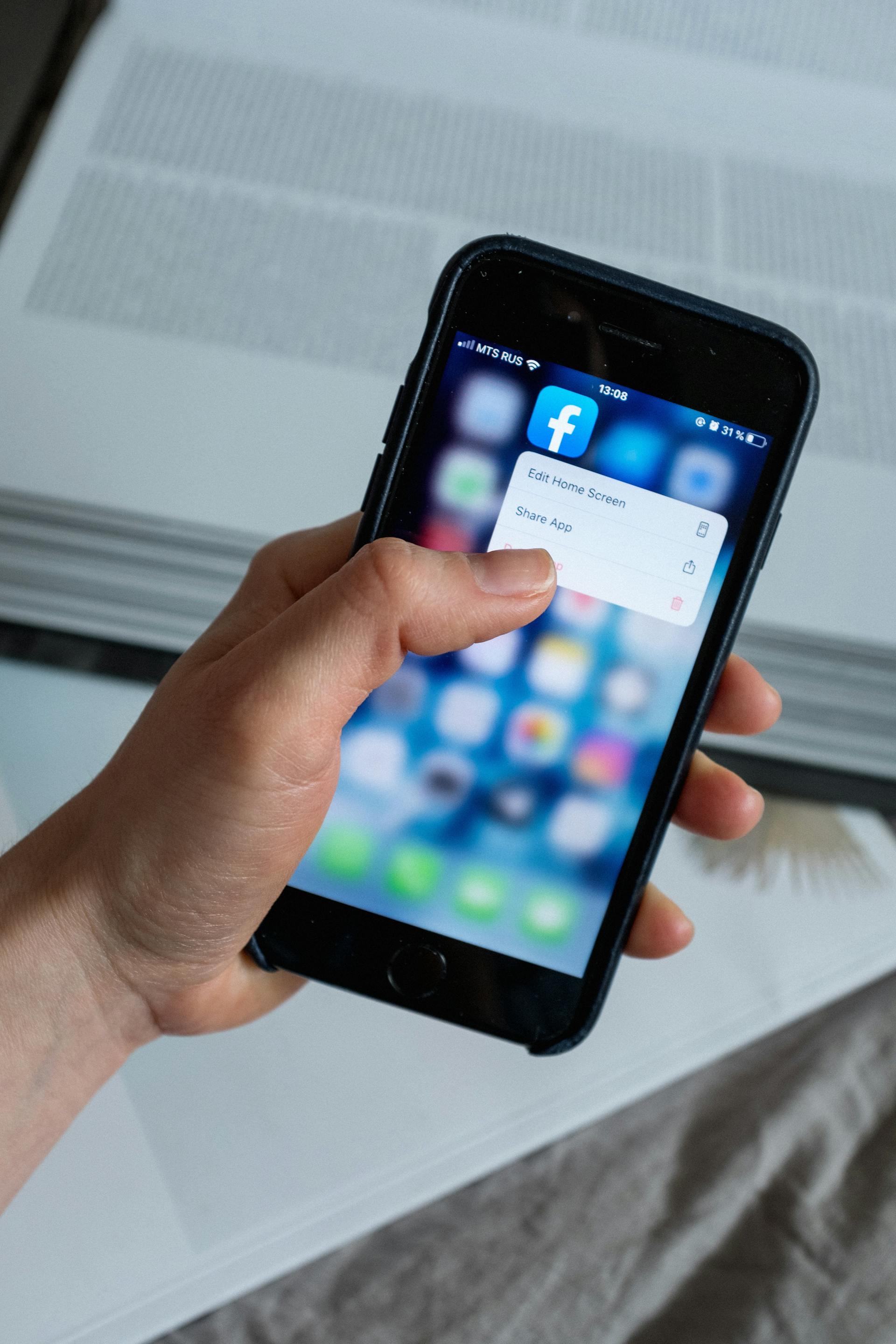 A closeup shot of a person holding a smartphone while touching the social media app icon on the screen | Source: Pexels