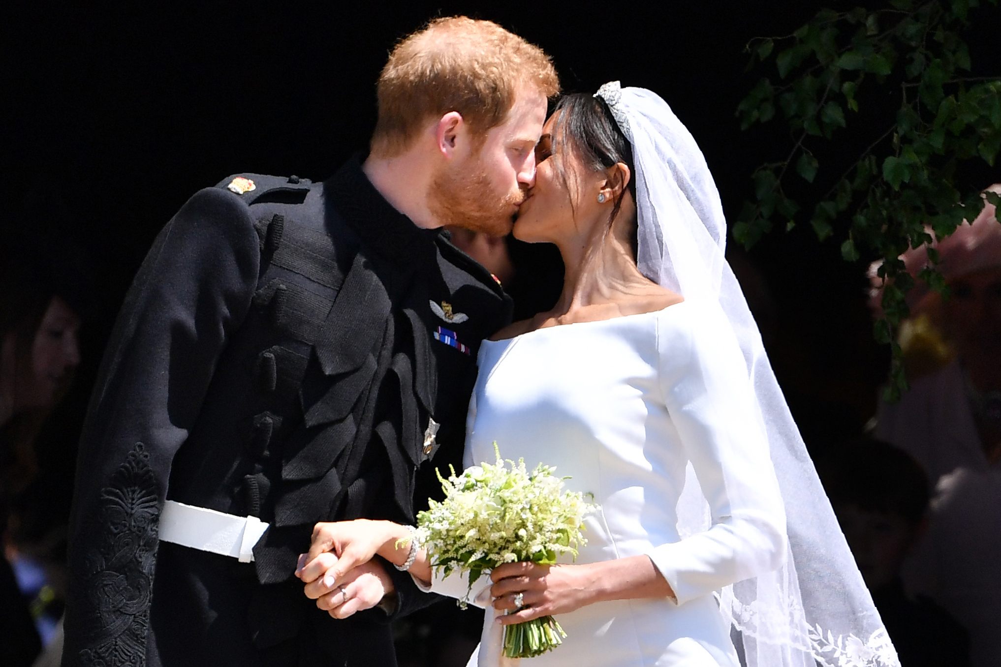 Prince Harry, Duke of Sussex kisses Meghan, Duchess of Sussex outside St George's Chapel in Windsor Castle, England, on May 19, 2018. | Source: Getty Images