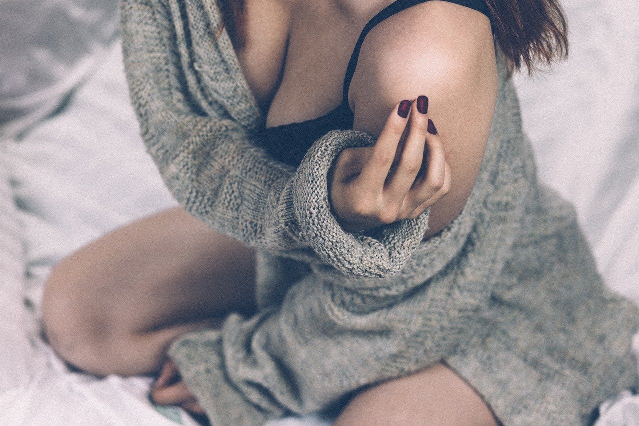 A woman posing in a sexy stance while wearing a sweater over some lingerie | Photo: Pixabay/Pexels