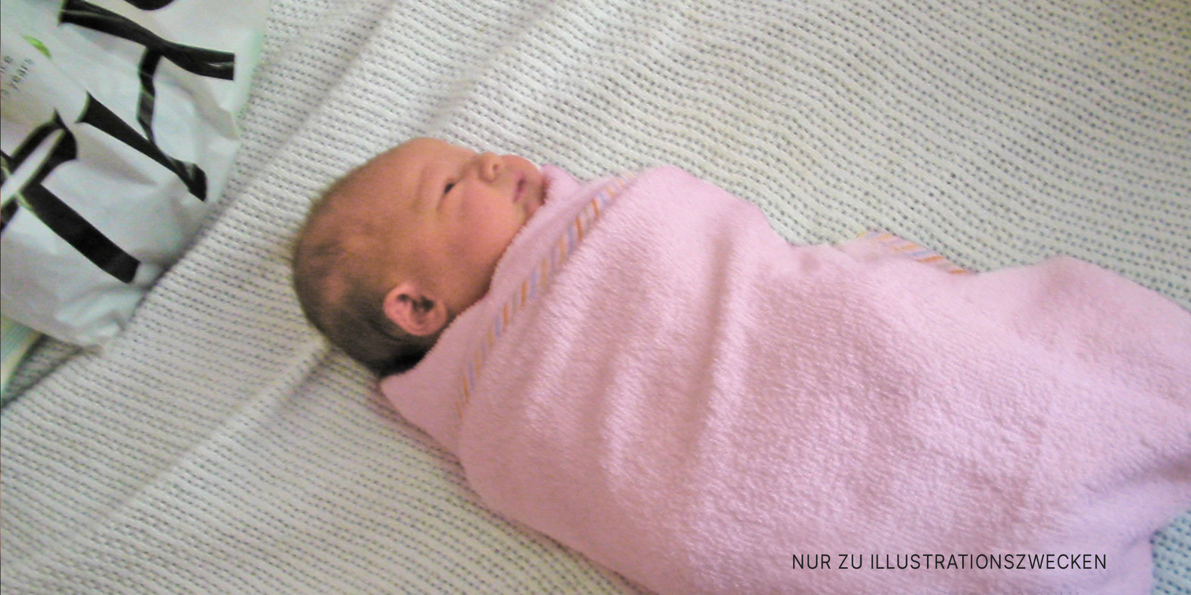 Süßes Baby in ein Handtuch gewickelt. | Quelle: Flickr / shegingerly (CC BY-SA 2.0)