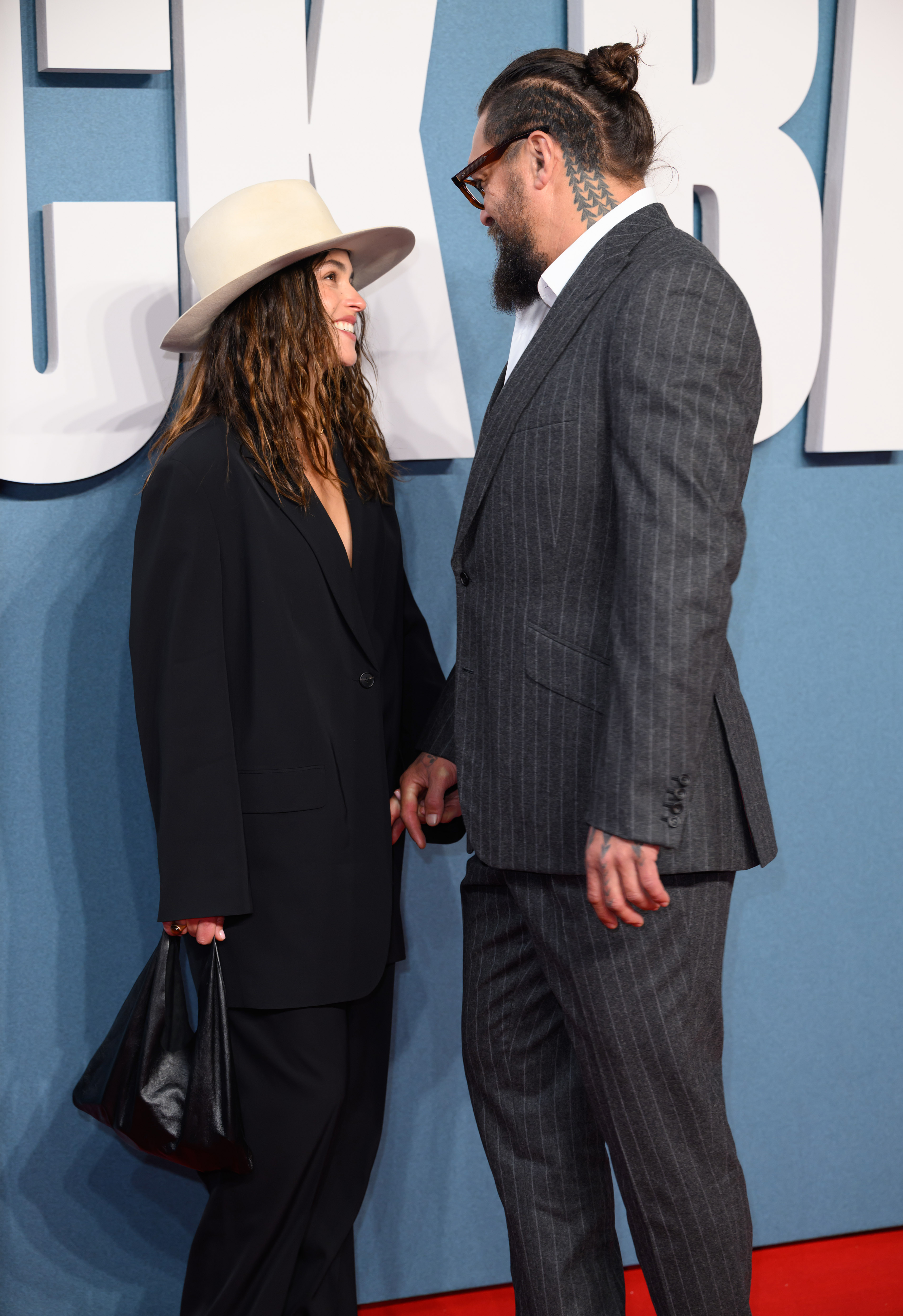 Adria Arjona and Jason Momoa exchanging smiles at the event. | Source: Getty Images