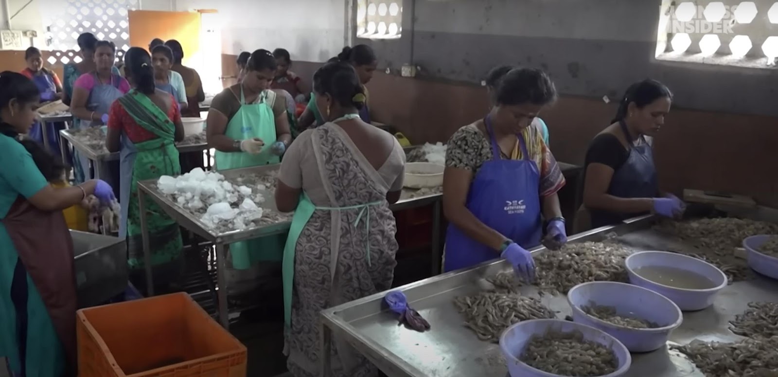 Workers processing and preparing shrimp. | Source: YouTube/ Business Insider