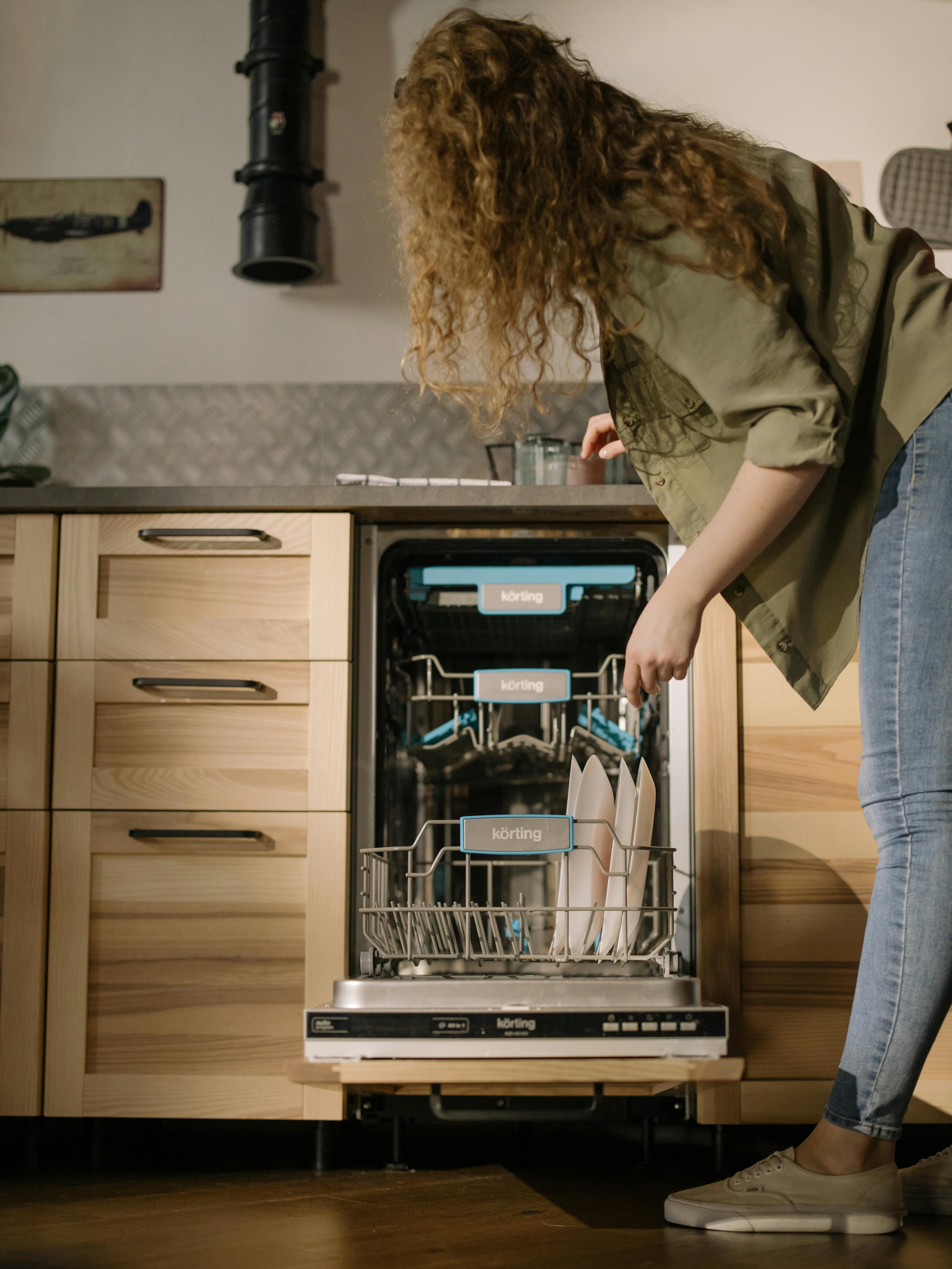 A woman loading a dishwasher | Source: Pexels