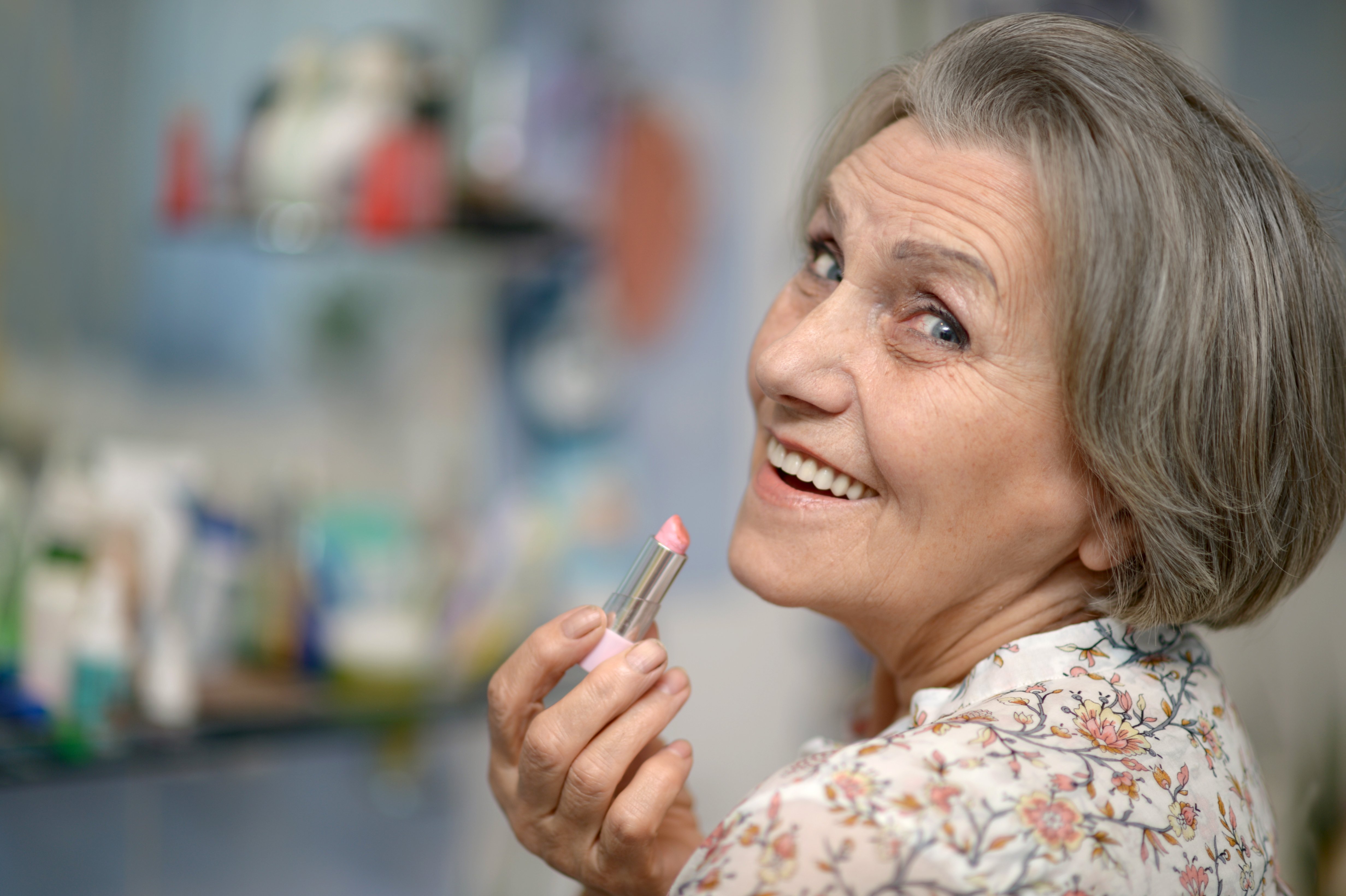 Magnifique portrait d'une femme âgée se maquillant avec du rouge à lèvres. | Photo : Shutterstock