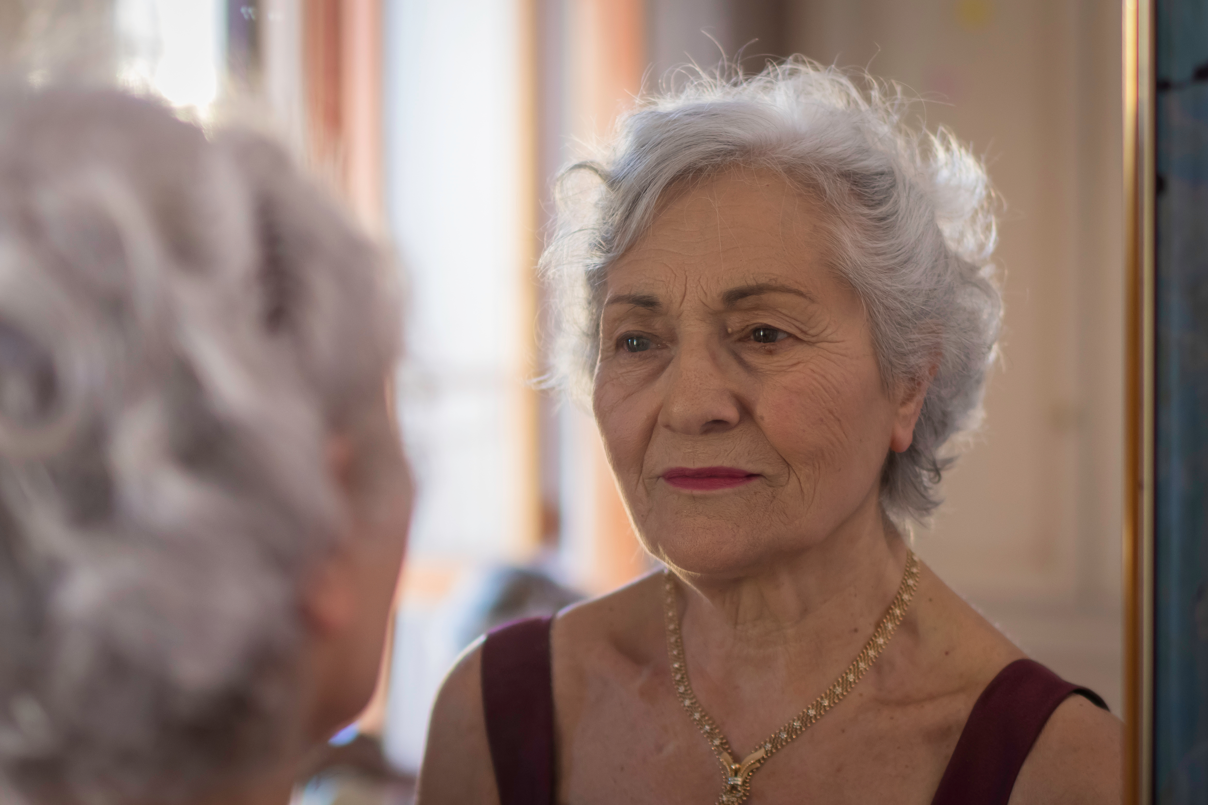 An elderly woman looking in the mirror | Source: Shutterstock